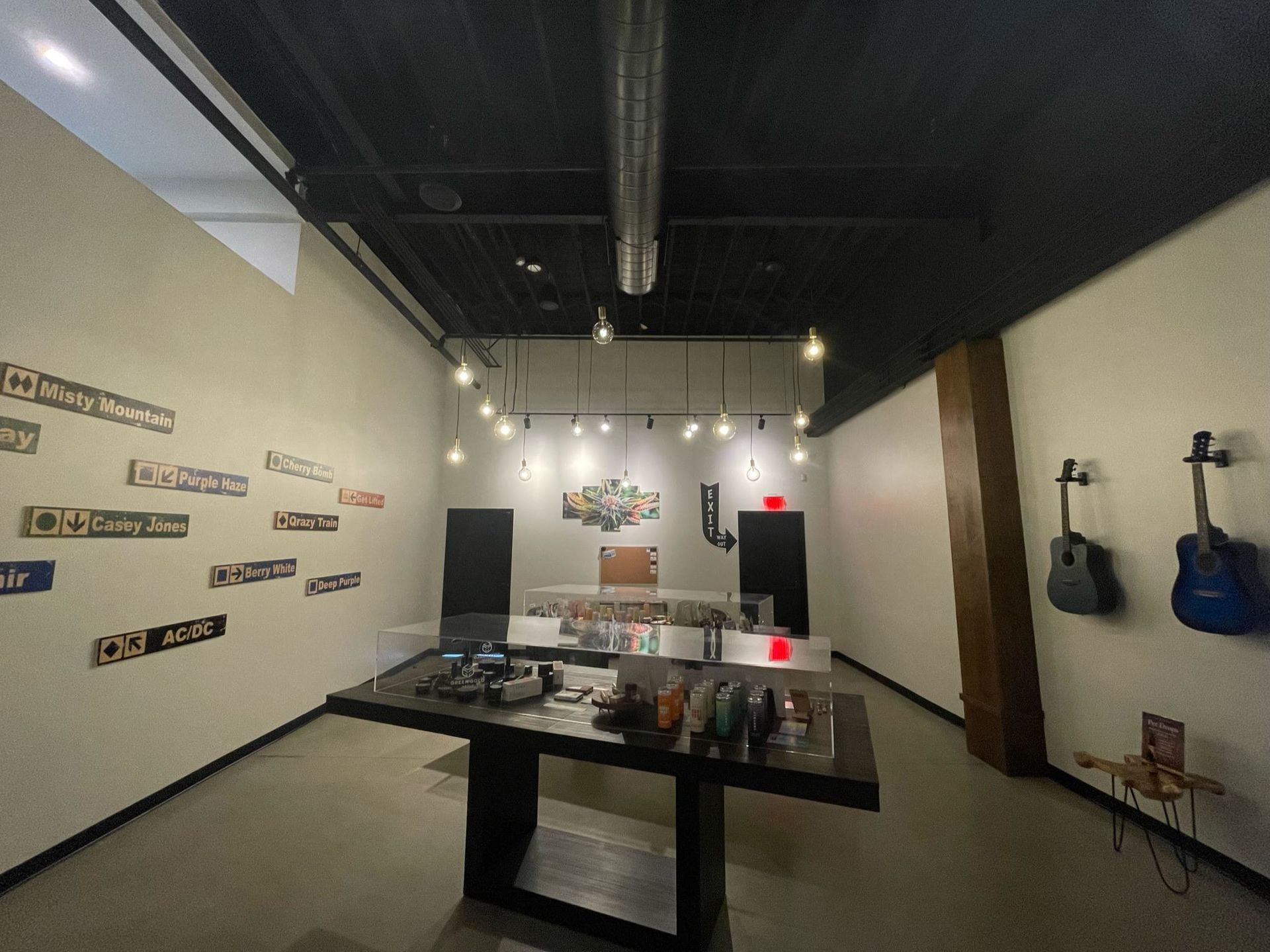 A room with a table and guitars on the wall