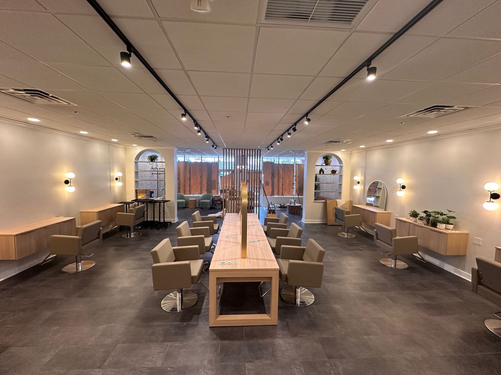 A large room with a long table and chairs in a hair salon.