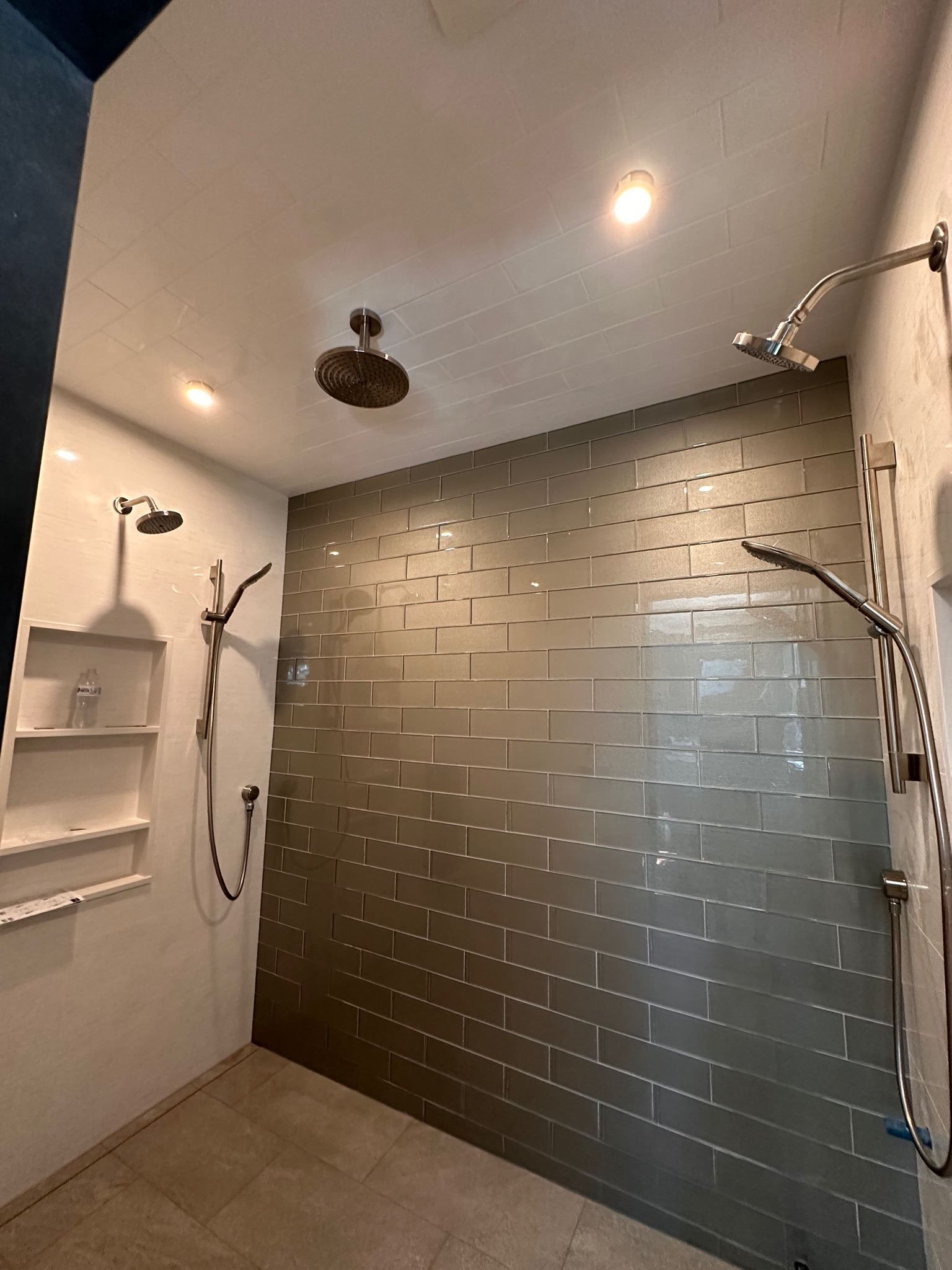 A bathroom with a walk in shower and two shower heads.