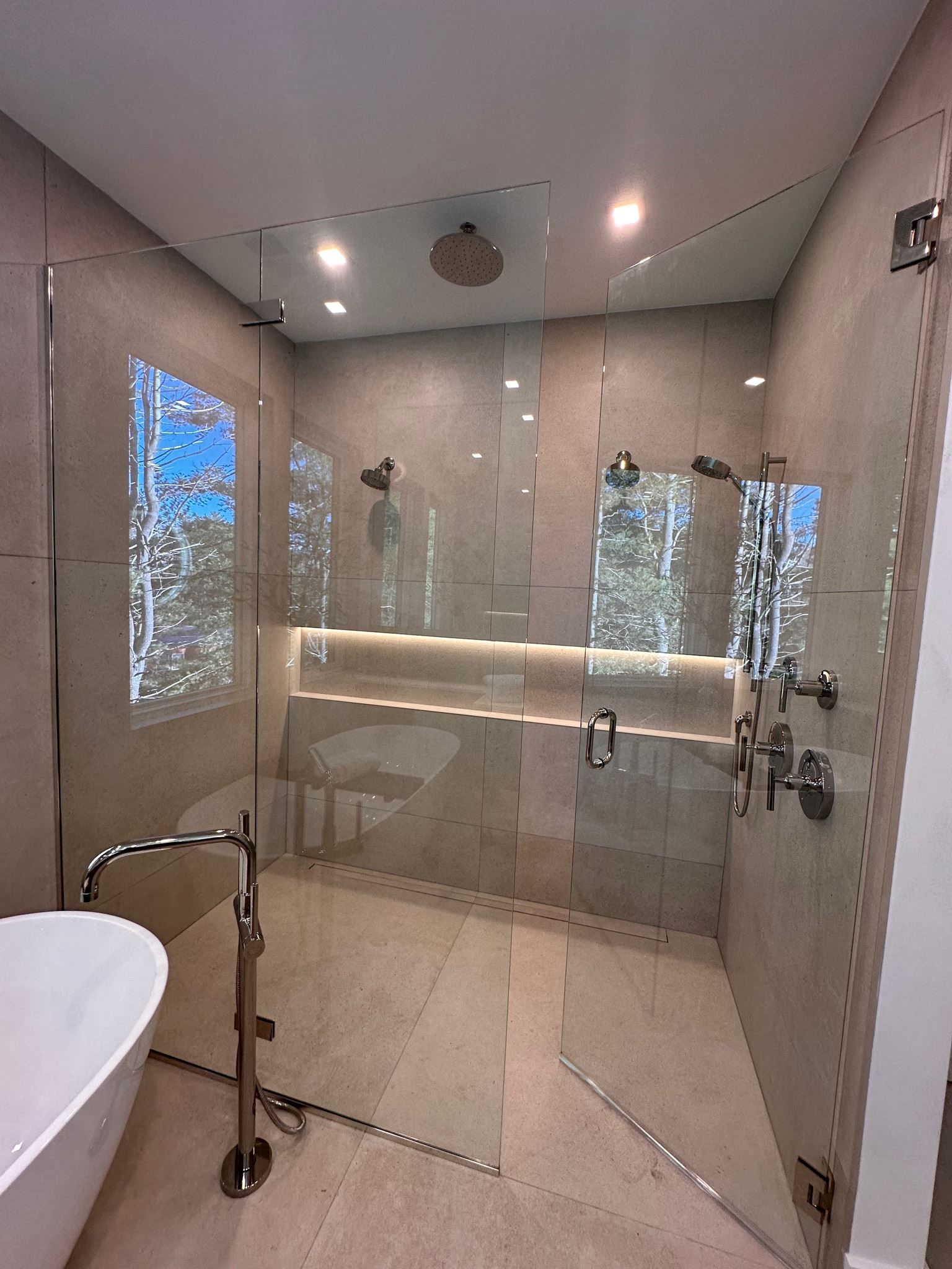 A bathroom with a walk in shower and a bathtub.