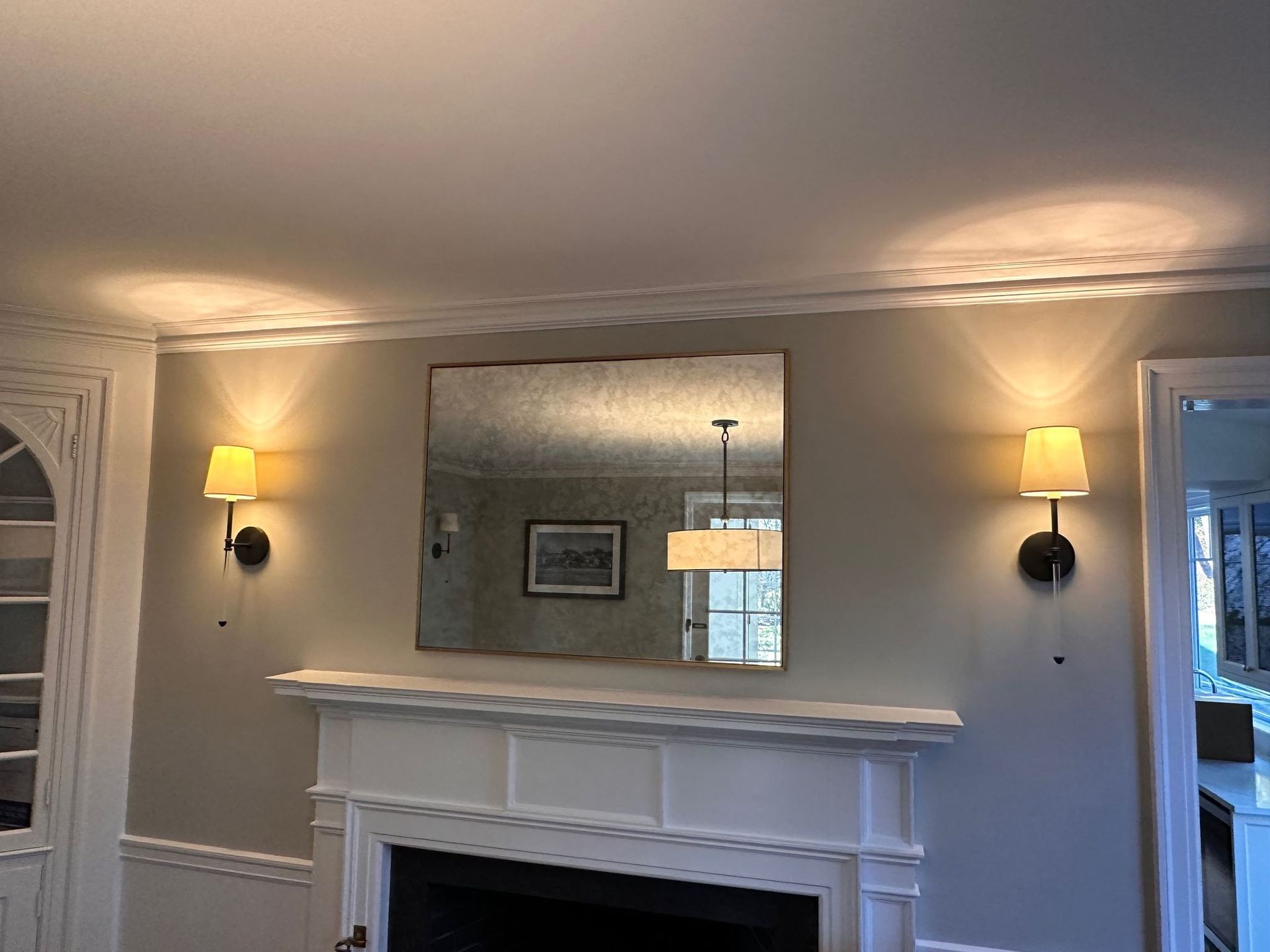 A living room with a fireplace and a mirror on the wall.