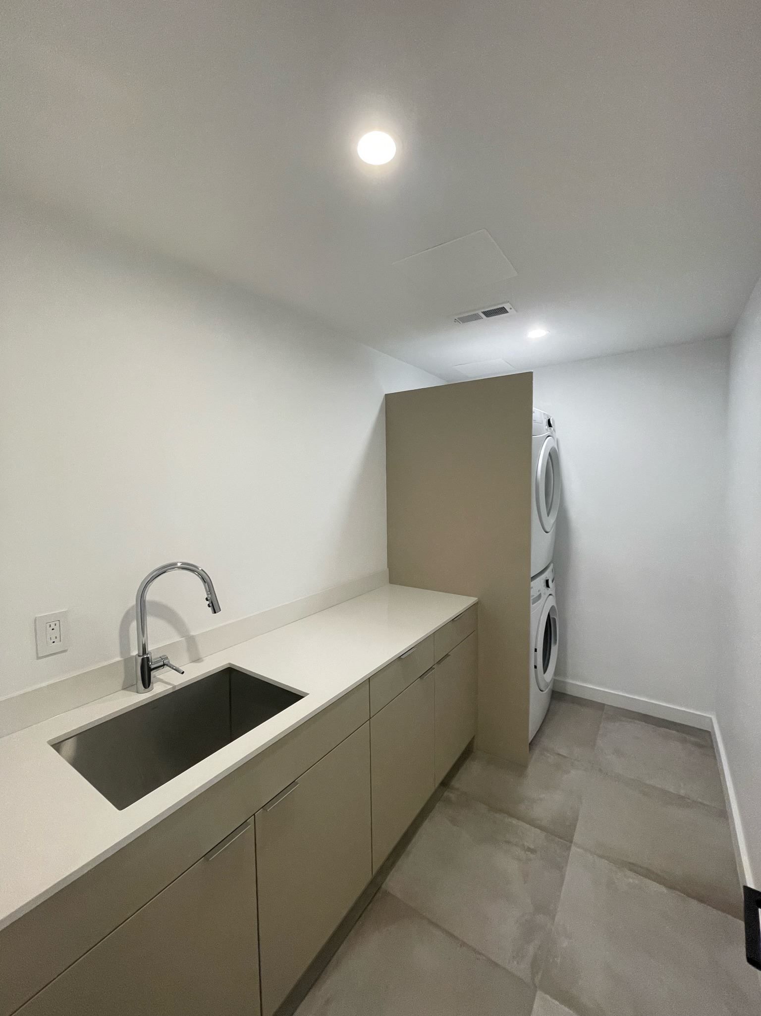 A kitchen with a sink and a washer and dryer