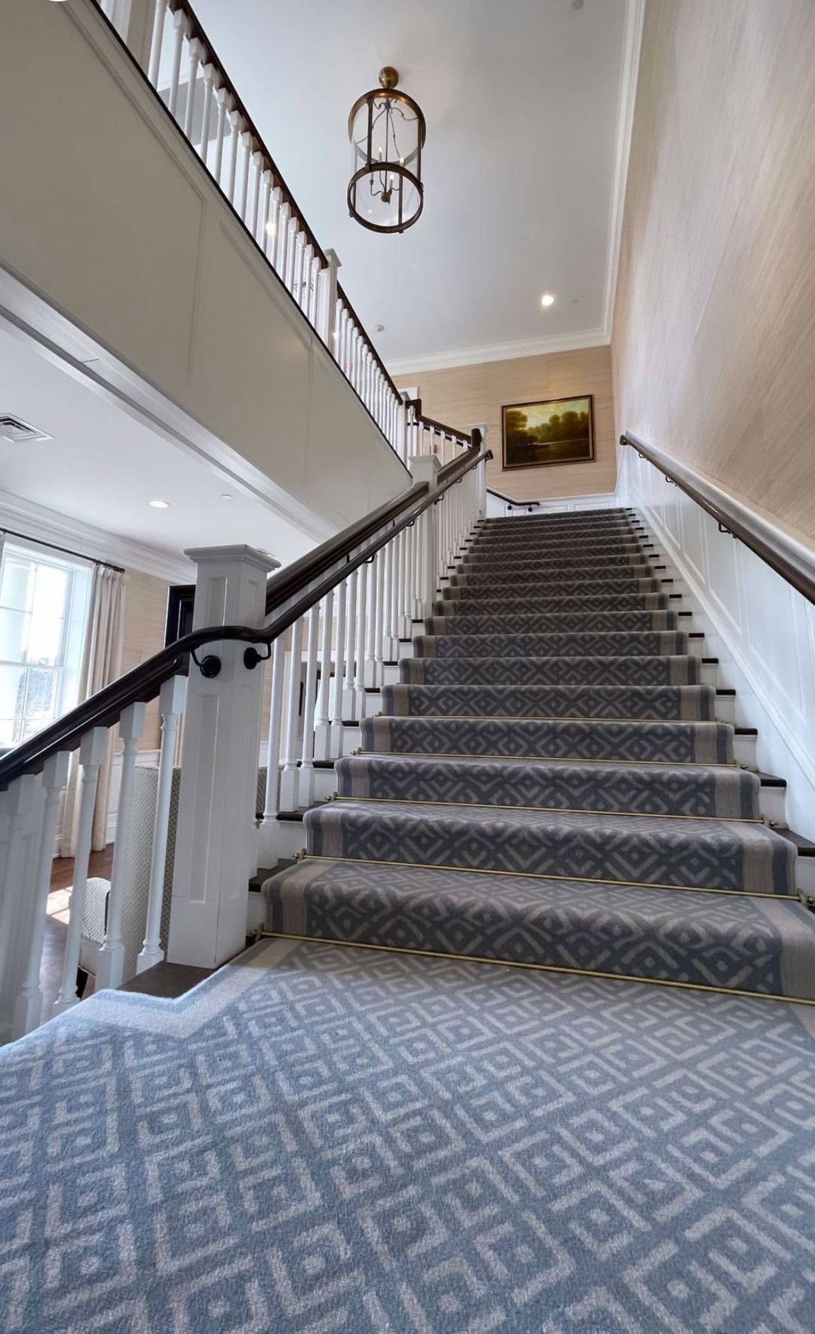 A staircase with a gray carpet and a white railing in a house.