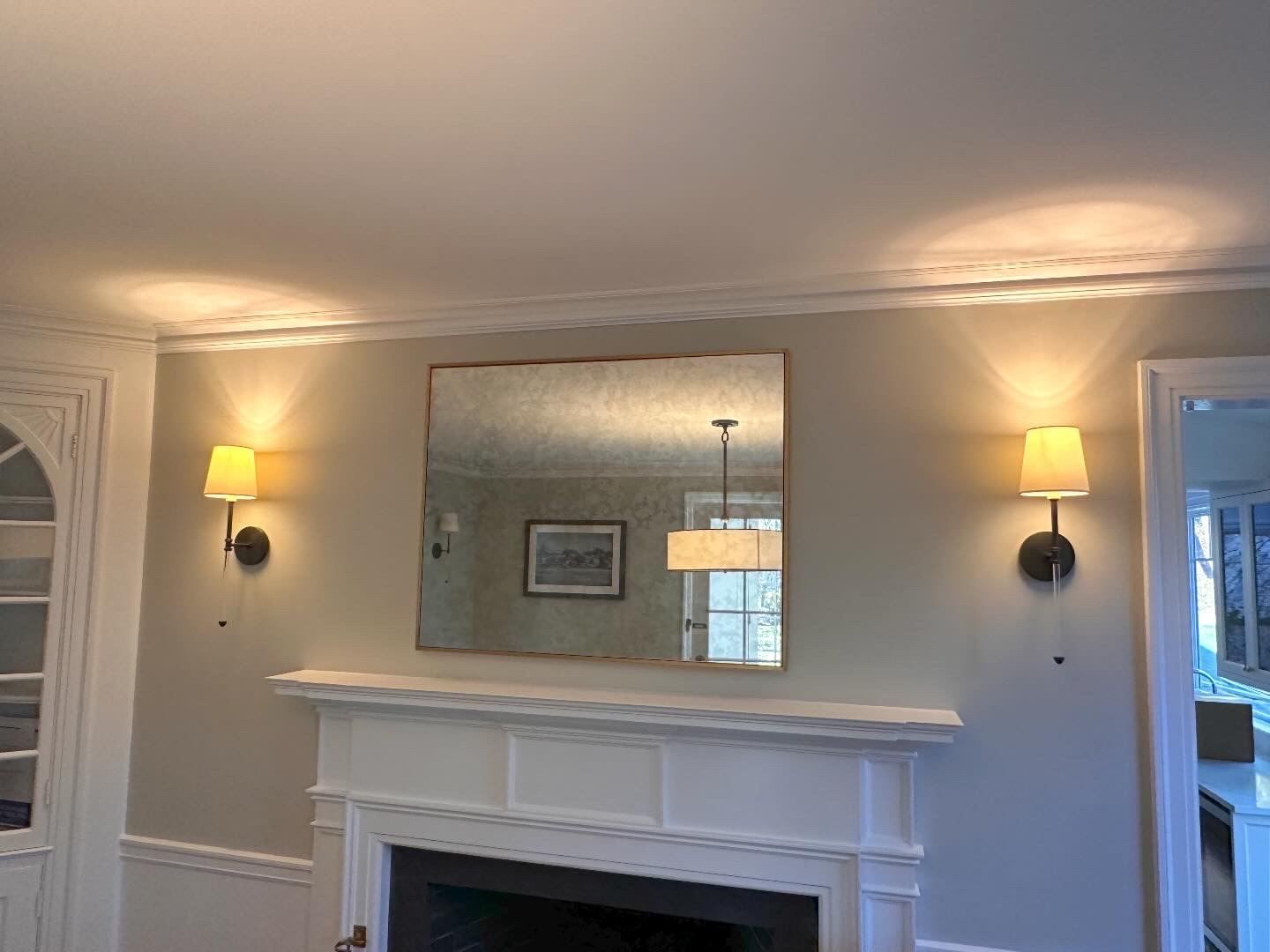 A living room with a fireplace and a mirror on the wall.