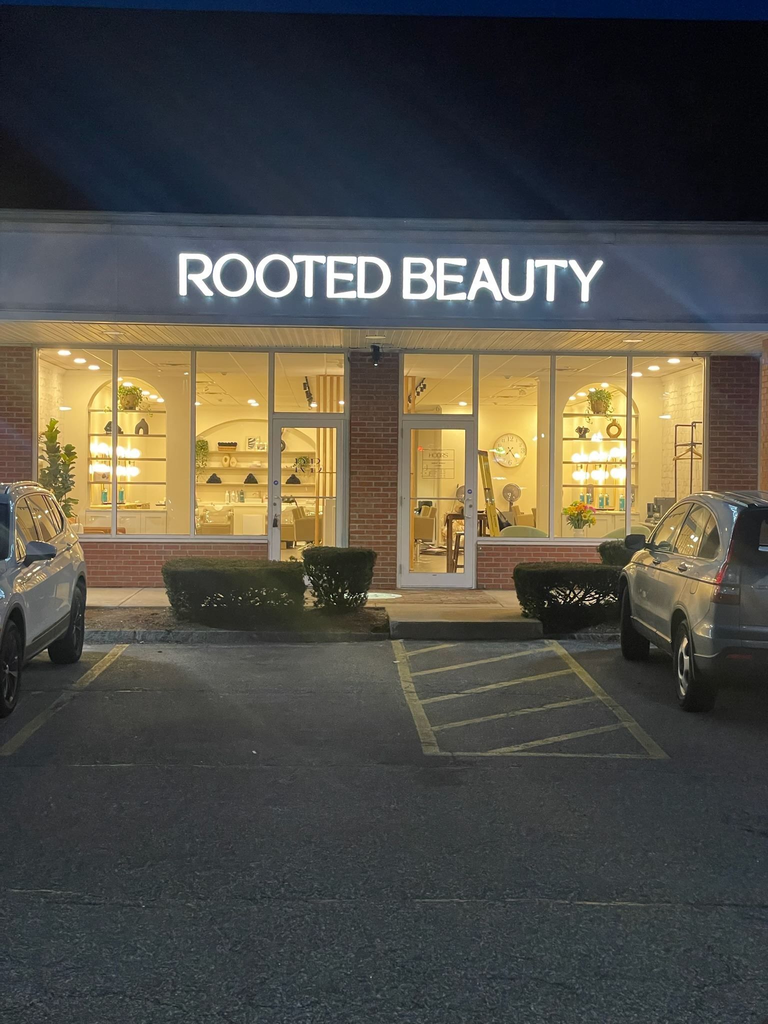 A rooted beauty store with cars parked in front of it
