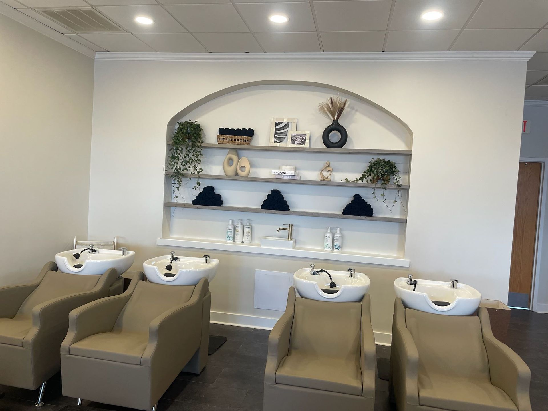 A room with a lot of chairs and sinks in it