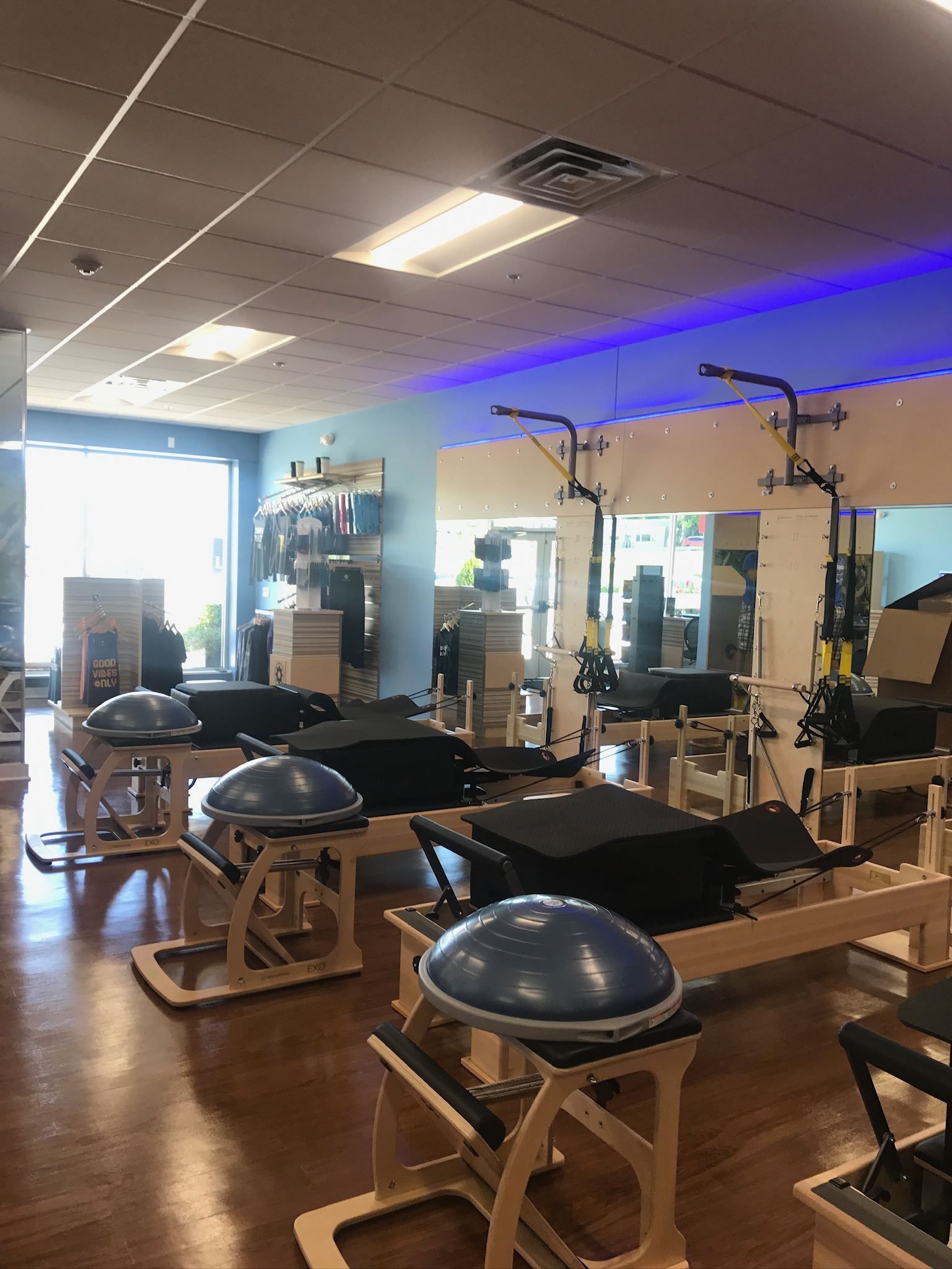 A gym filled with lots of exercise equipment and a blue light on the ceiling.