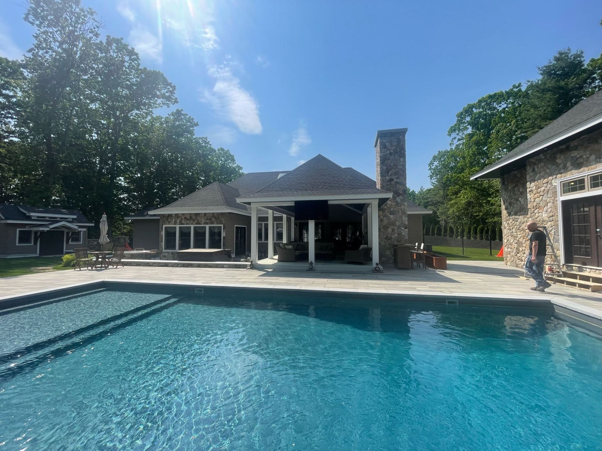 There is a large swimming pool in front of a house.