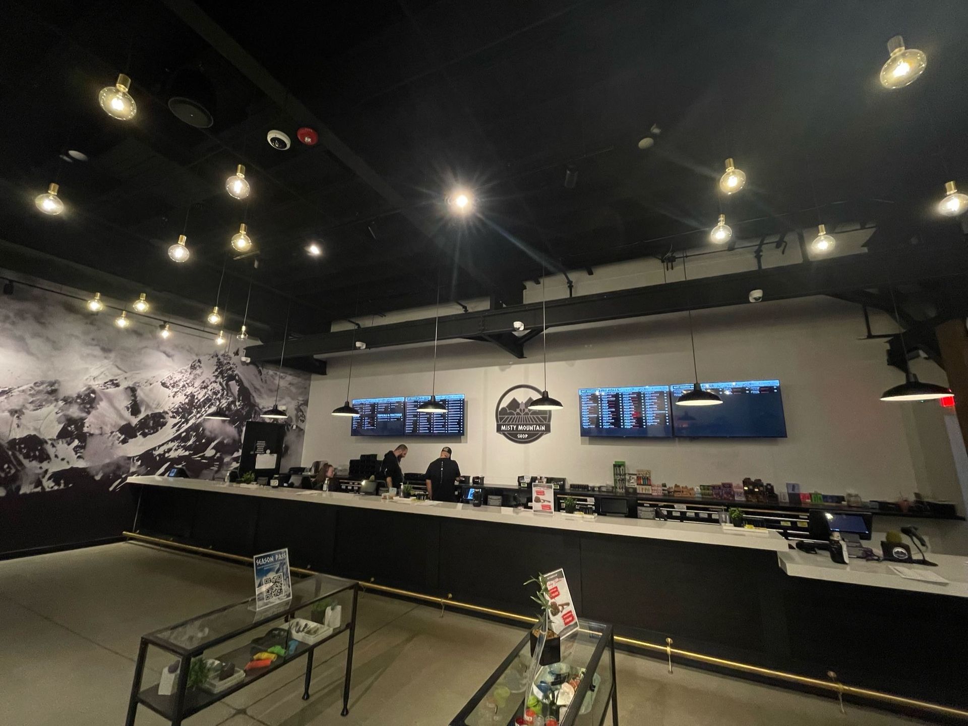 A restaurant with a long counter and a large mural on the wall.