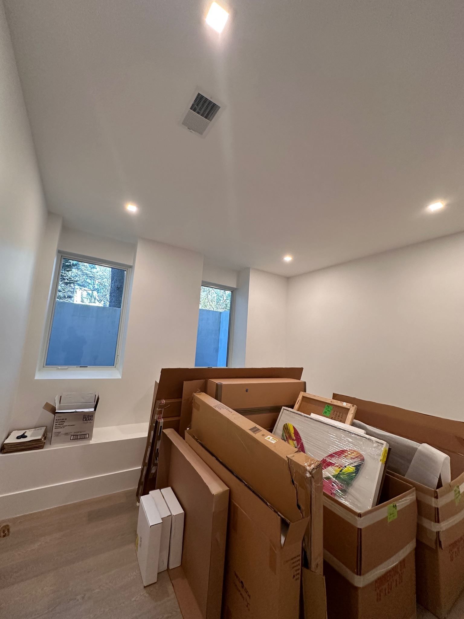 A room filled with lots of cardboard boxes and a window.