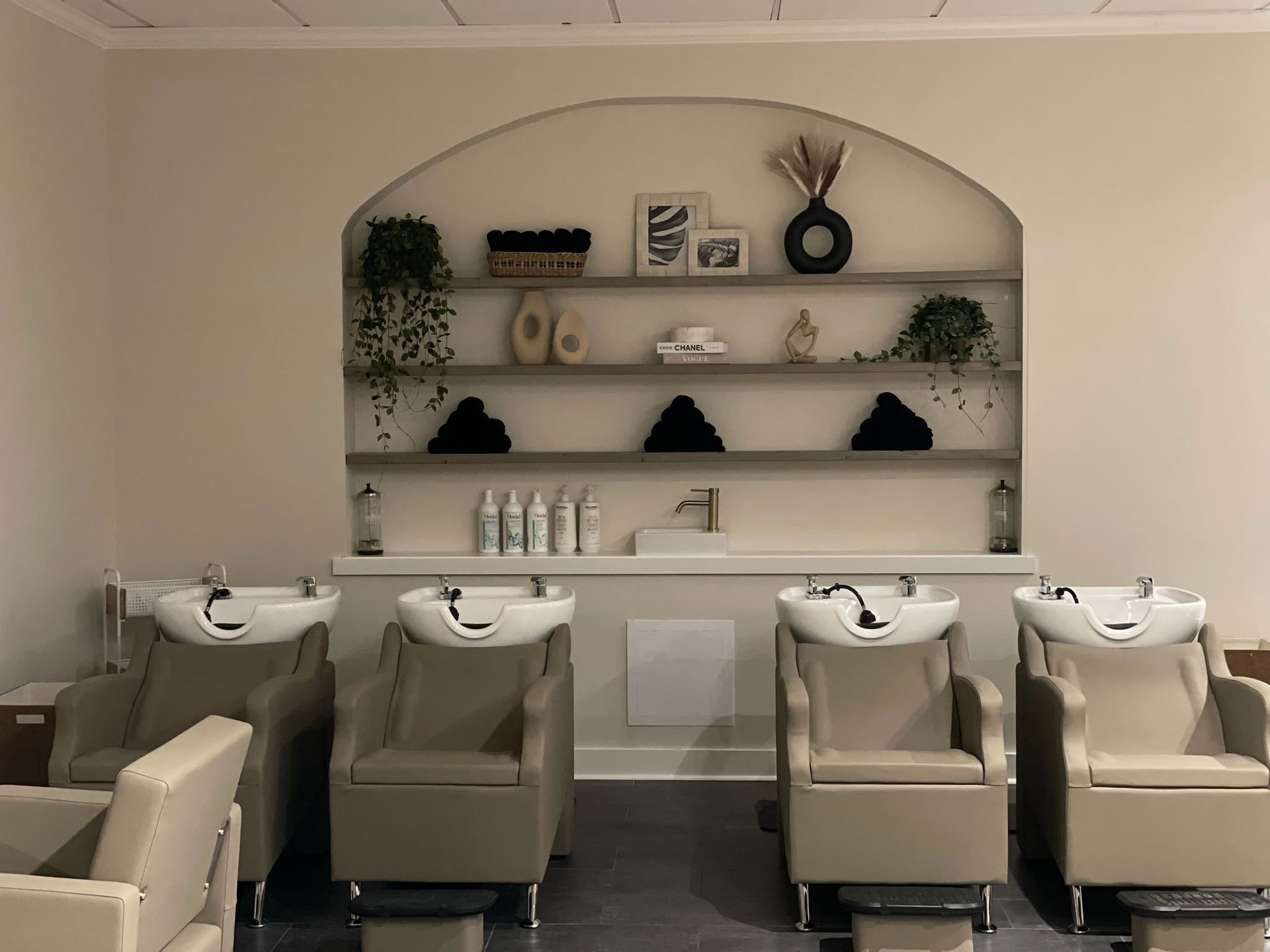 A row of chairs and sinks in a hair salon.