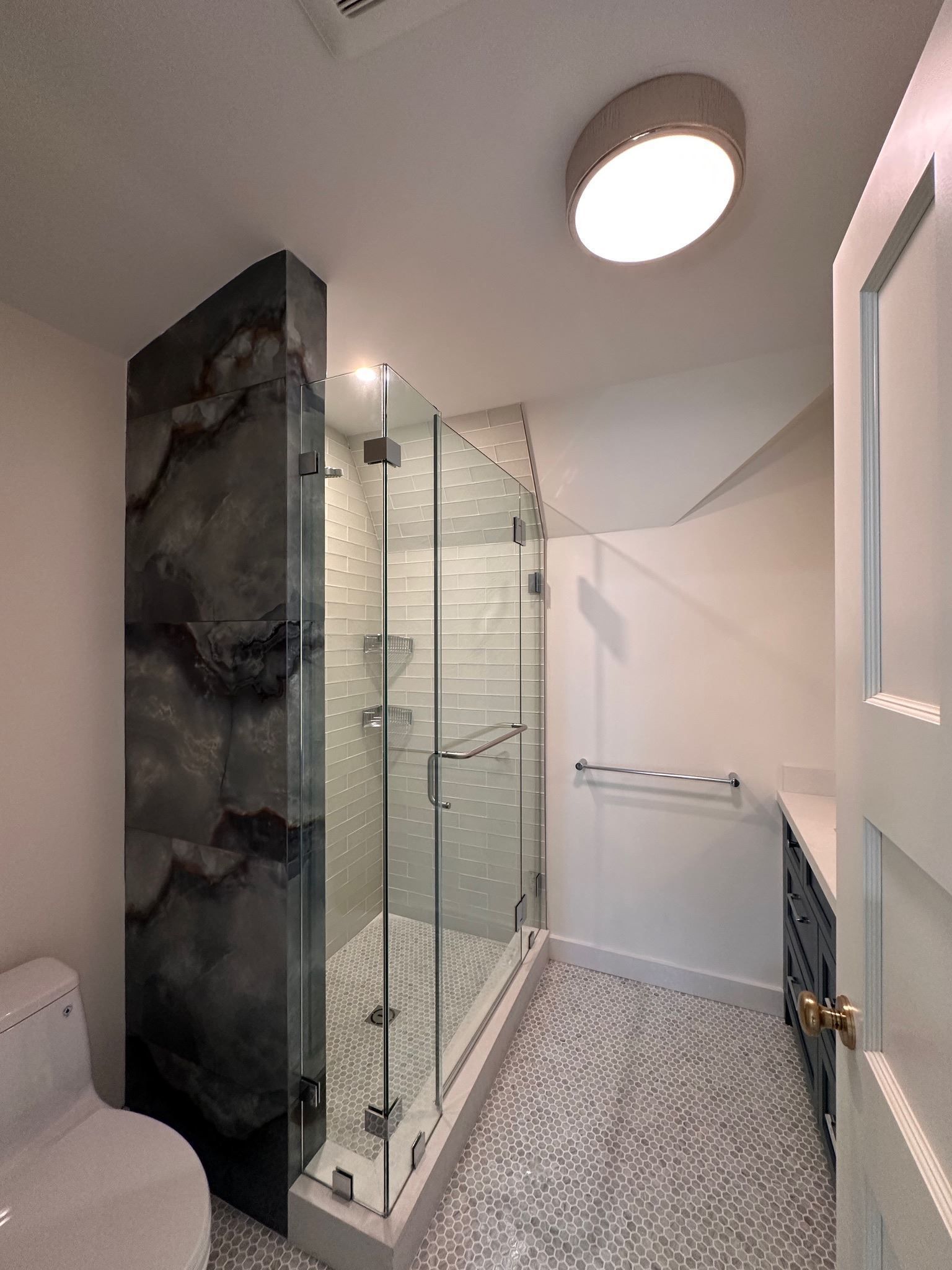 A bathroom with a walk in shower and a toilet.