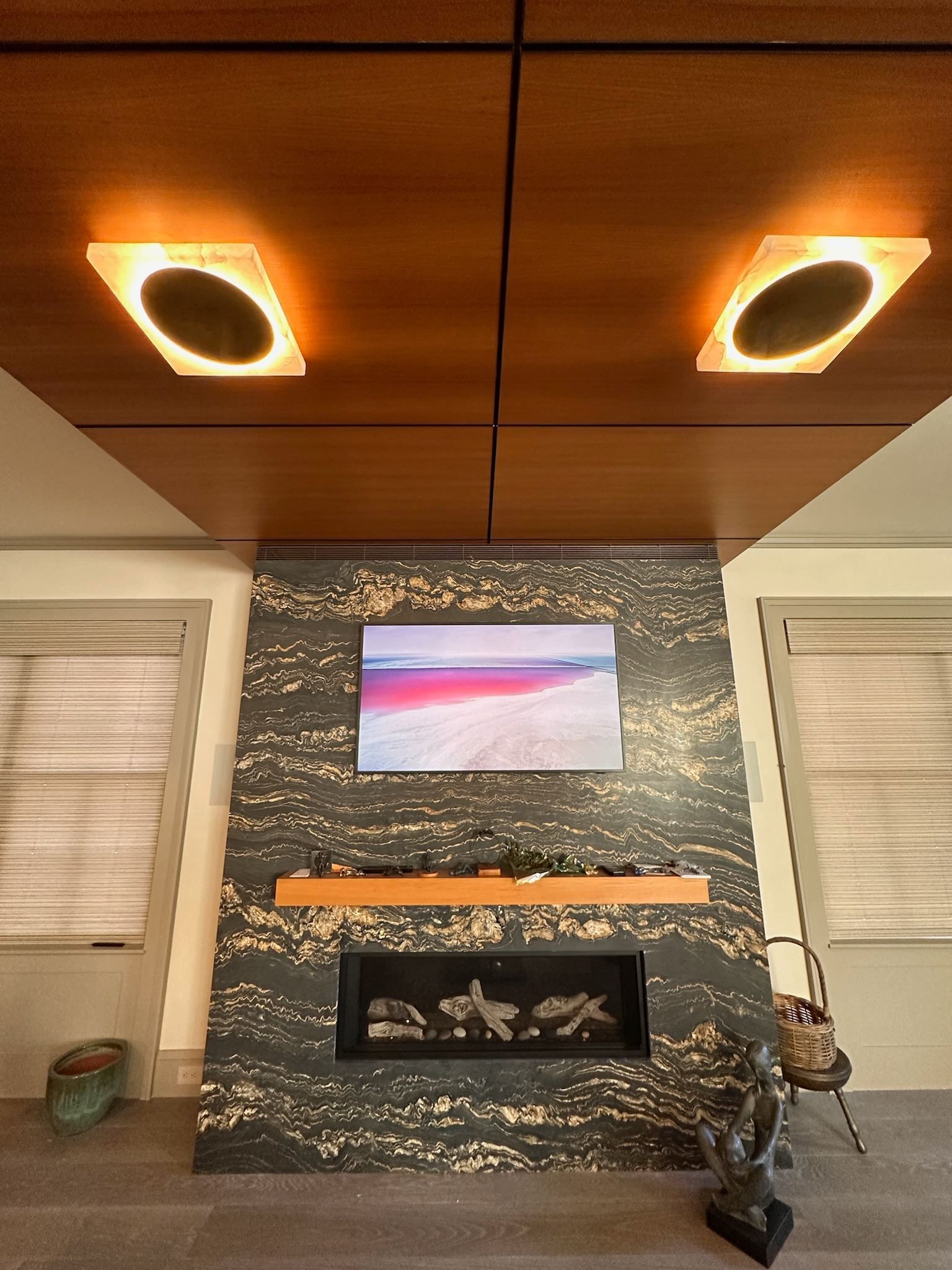 A living room with a fireplace and a flat screen tv on the wall.