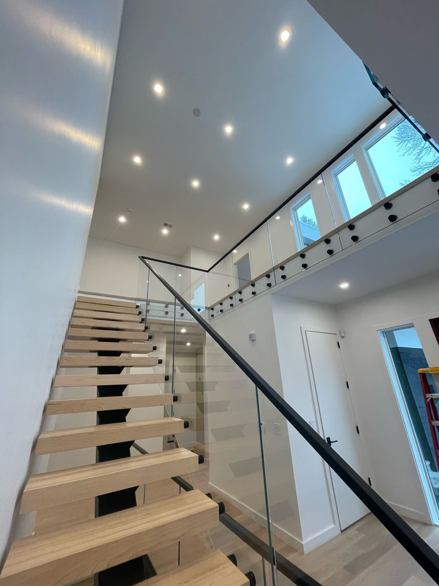 A wooden staircase with a glass railing in a house