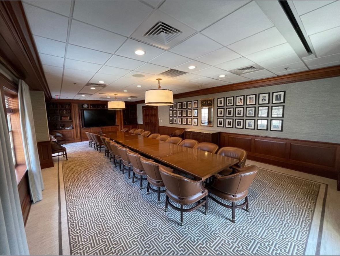 A large conference room with a long table and chairs.