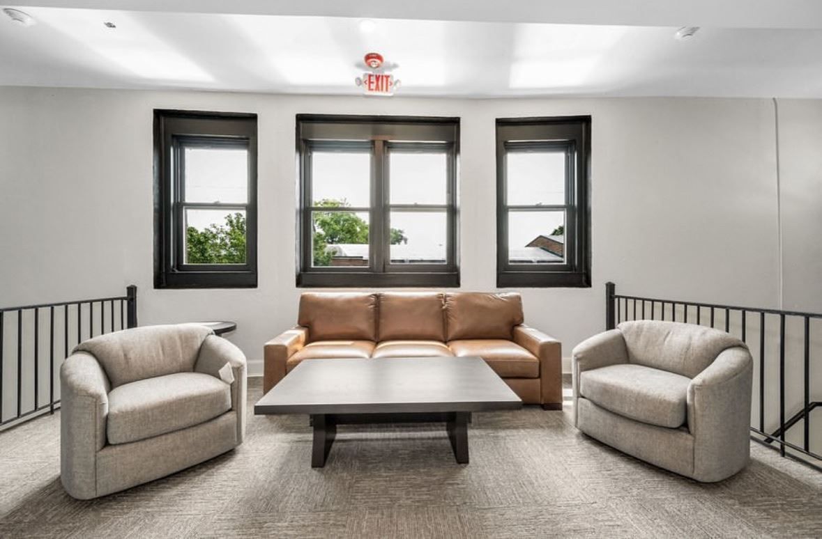 A living room with a couch , two chairs and a coffee table.
