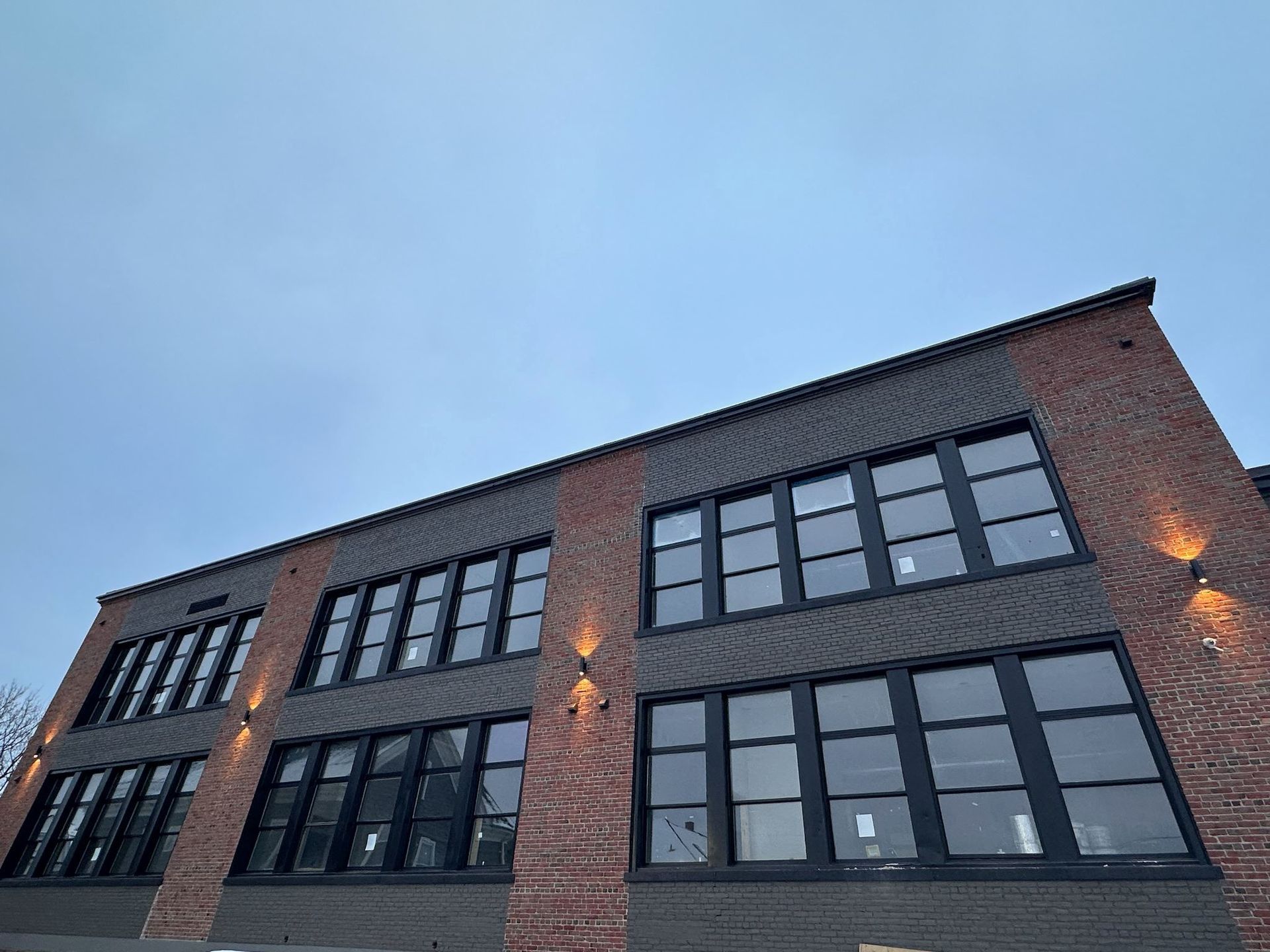 A large brick building with a lot of windows and a blue sky in the background.