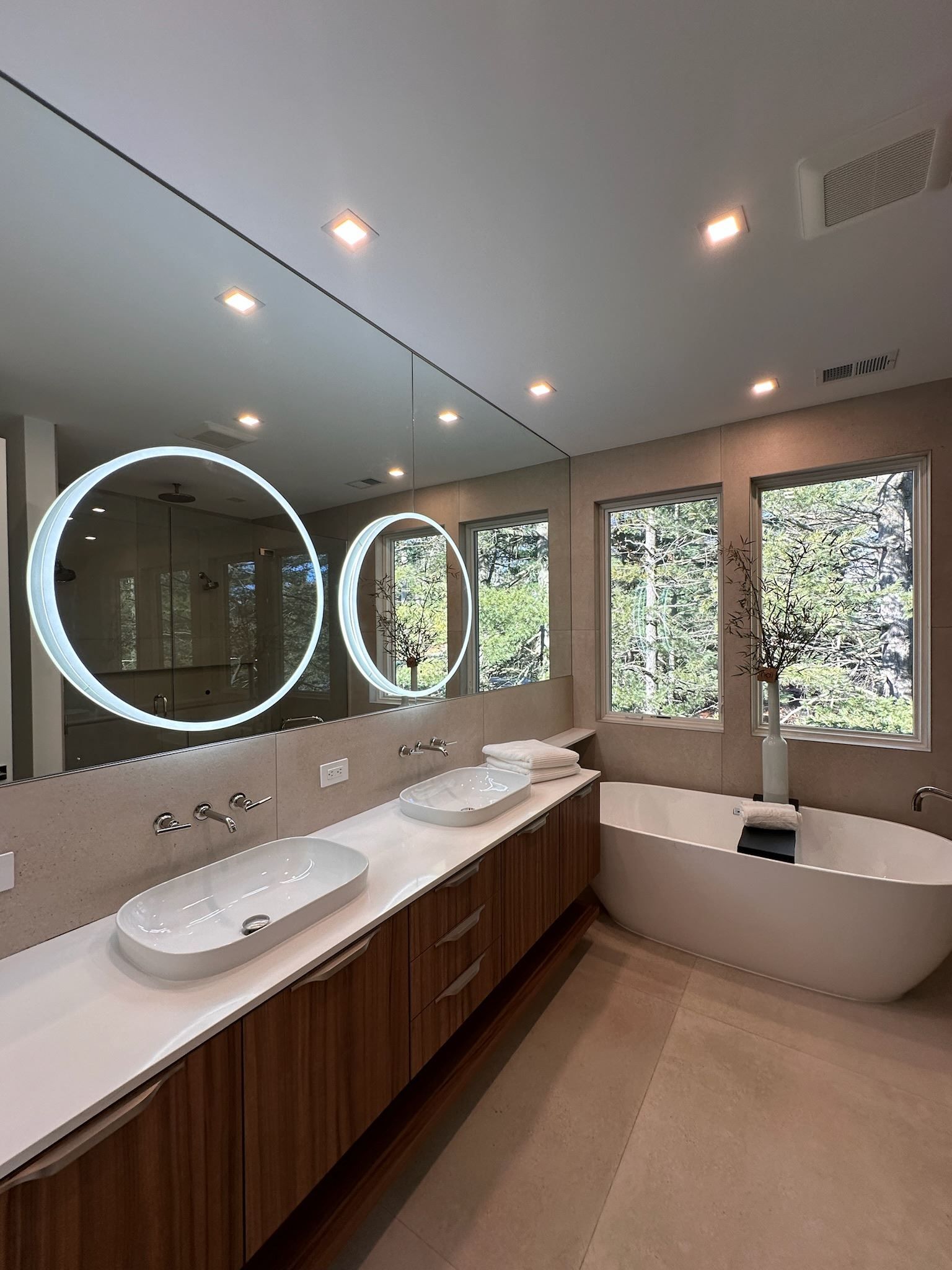 A bathroom with two sinks and a large mirror