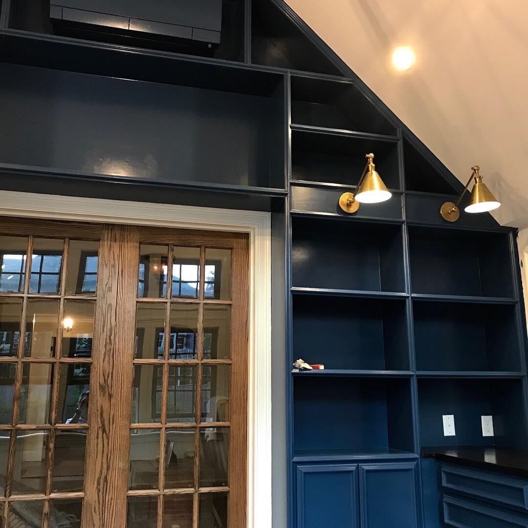 A room with a lot of shelves and a window