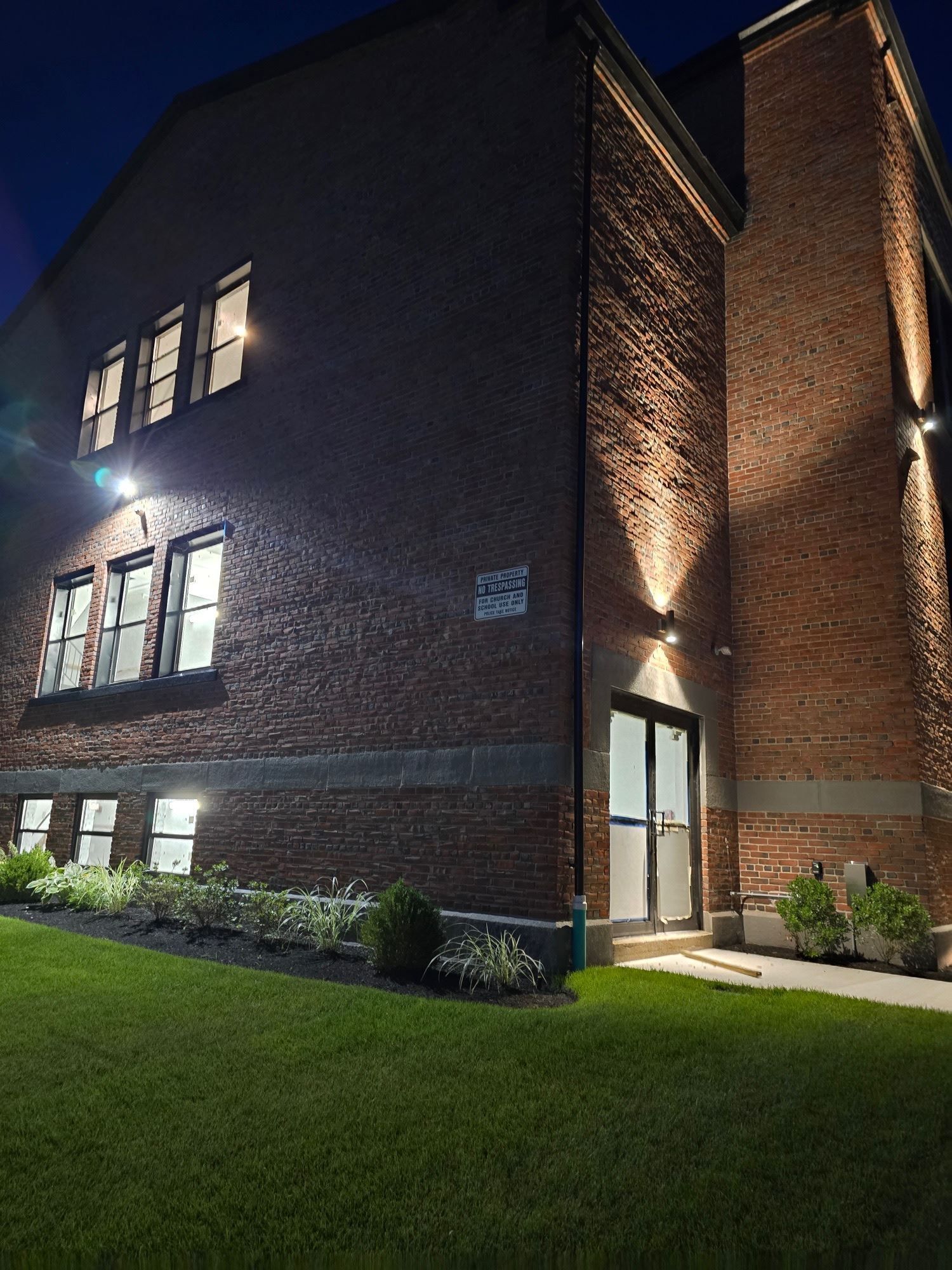 A large brick building is lit up at night