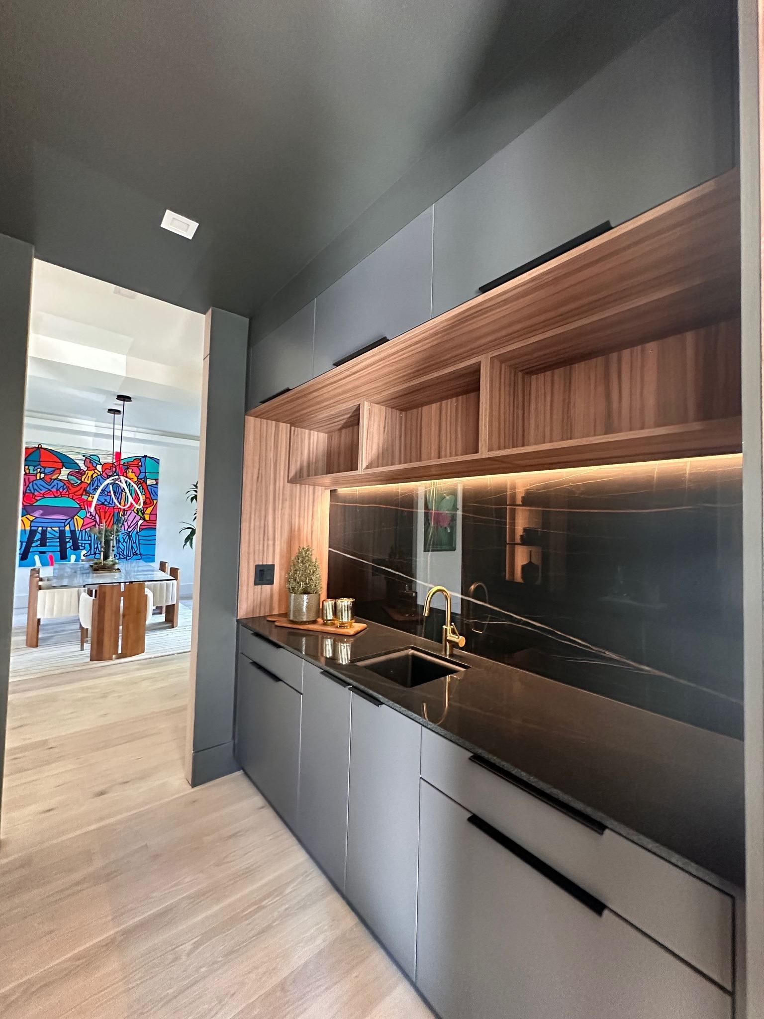 A kitchen with a sink , cabinets and a stainless steel counter top.