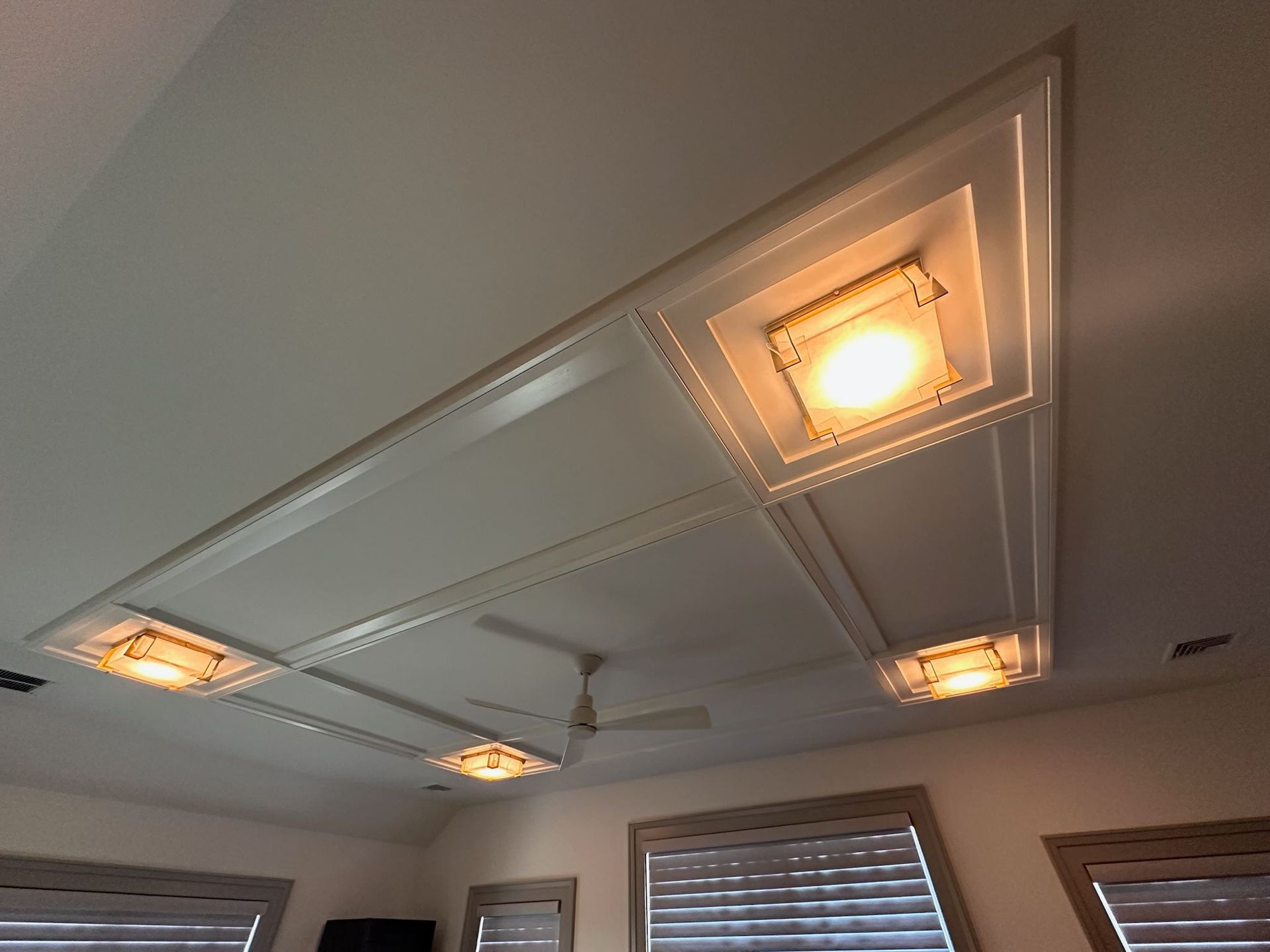 A room with a ceiling fan and a ceiling light