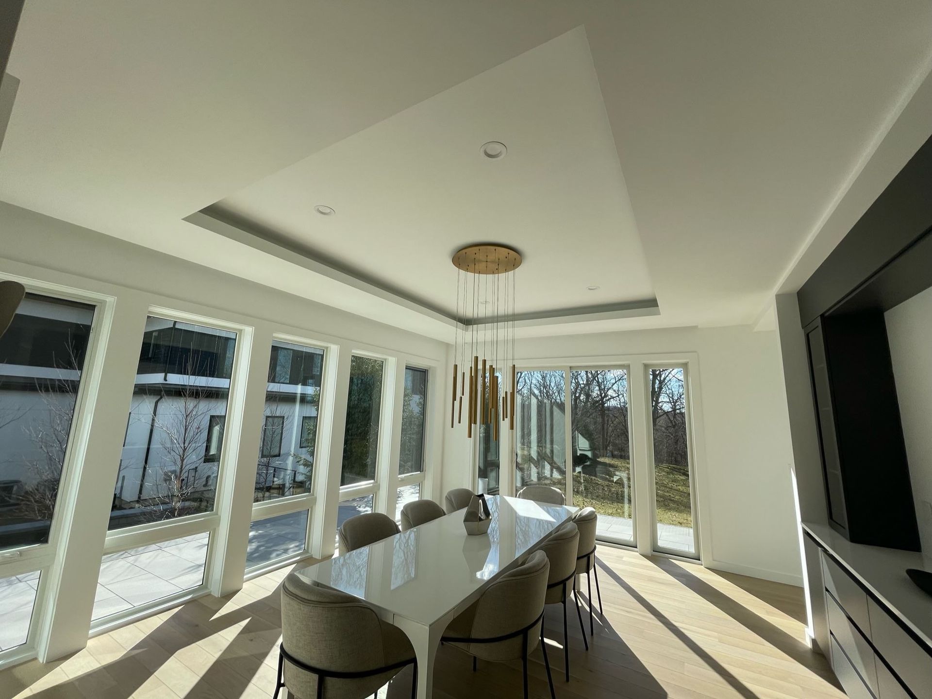 A large dining room with a table and chairs and a chandelier hanging from the ceiling.