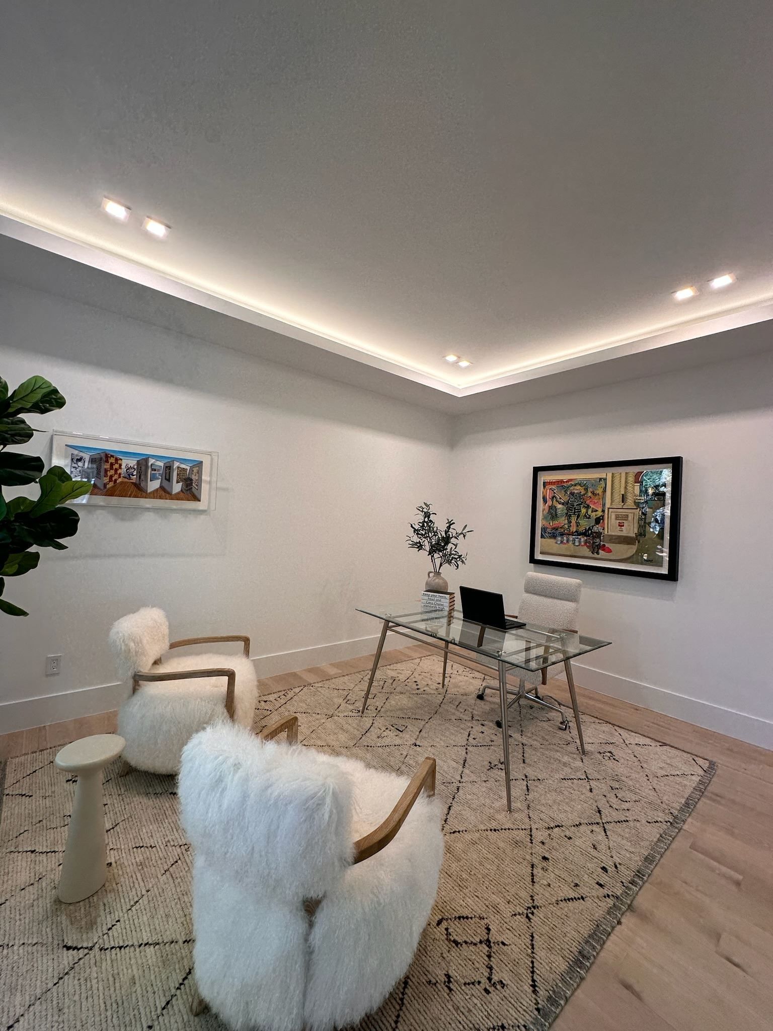 A living room with two chairs , a desk and a television.