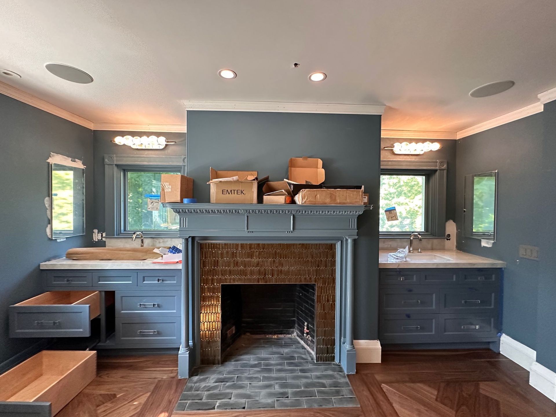 A bathroom with a fireplace and boxes on the mantle
