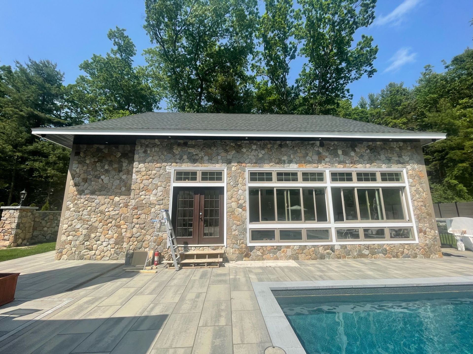 A stone house with a swimming pool in front of it