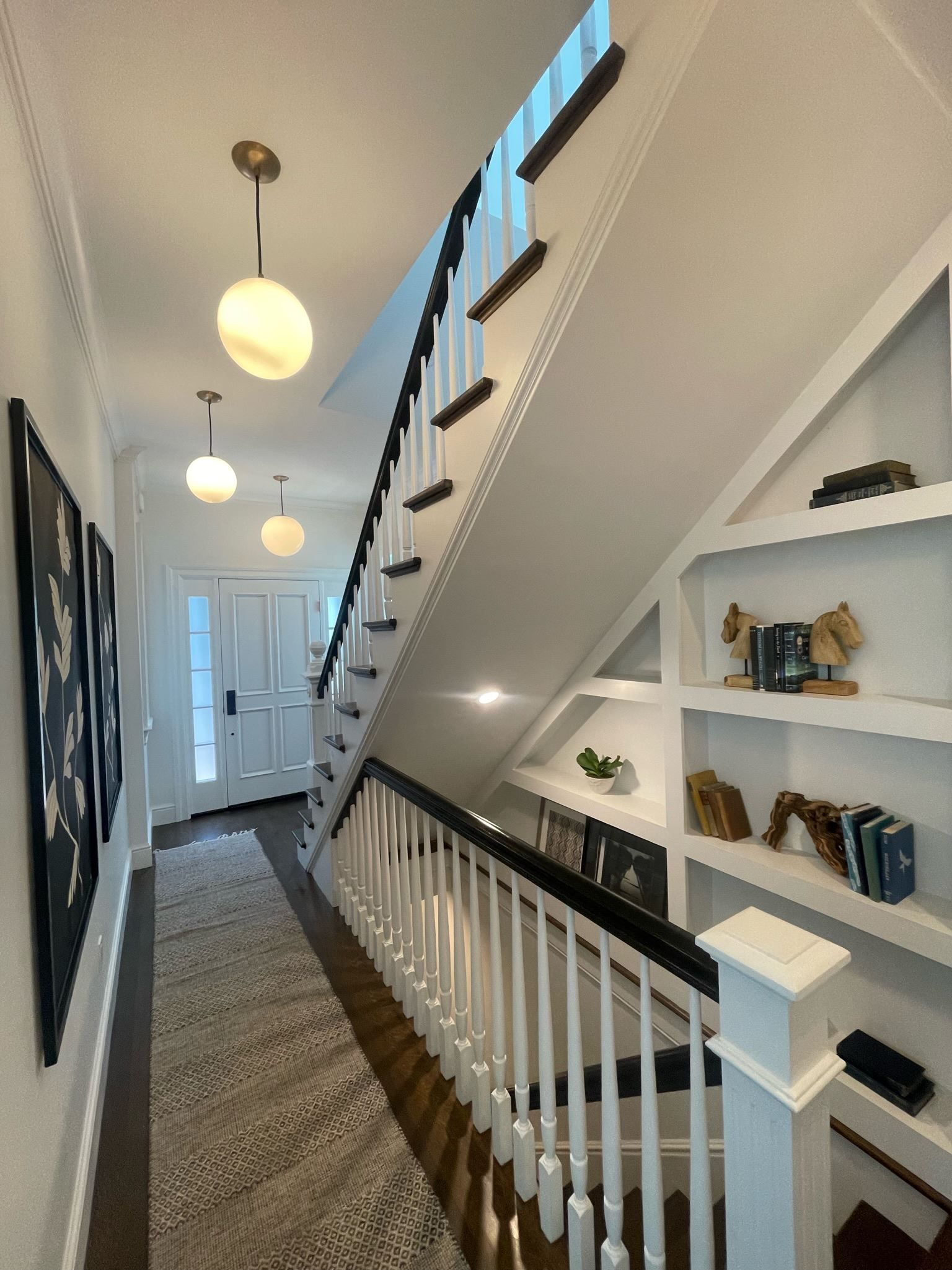 A hallway with a staircase leading up to the second floor