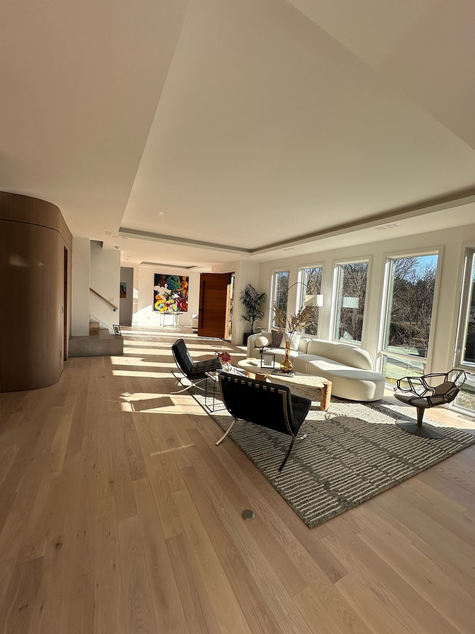 A living room with a couch , chairs , and a rug.