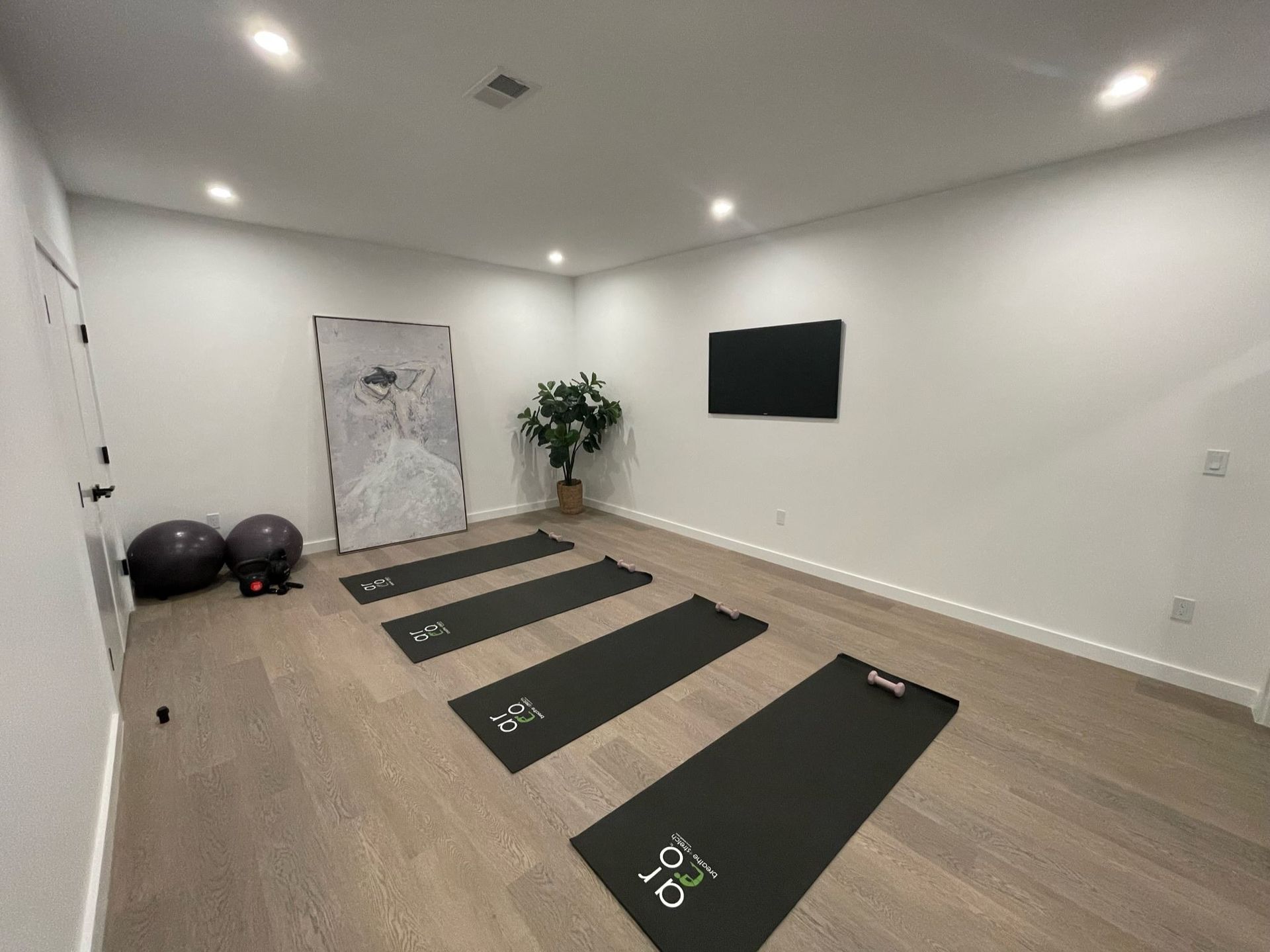 A room with a lot of yoga mats on the floor.