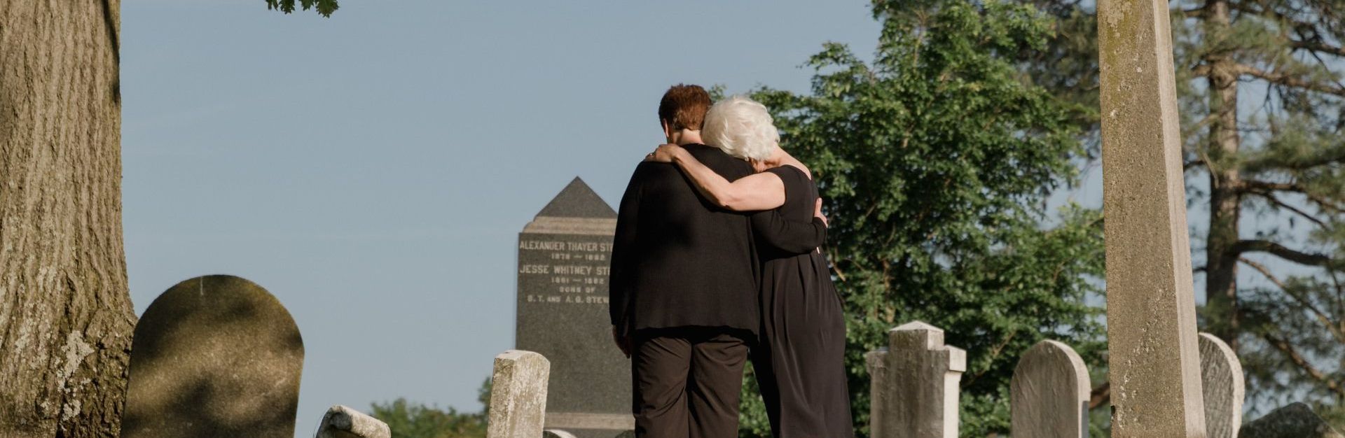 2 people comforting each other at a funeral