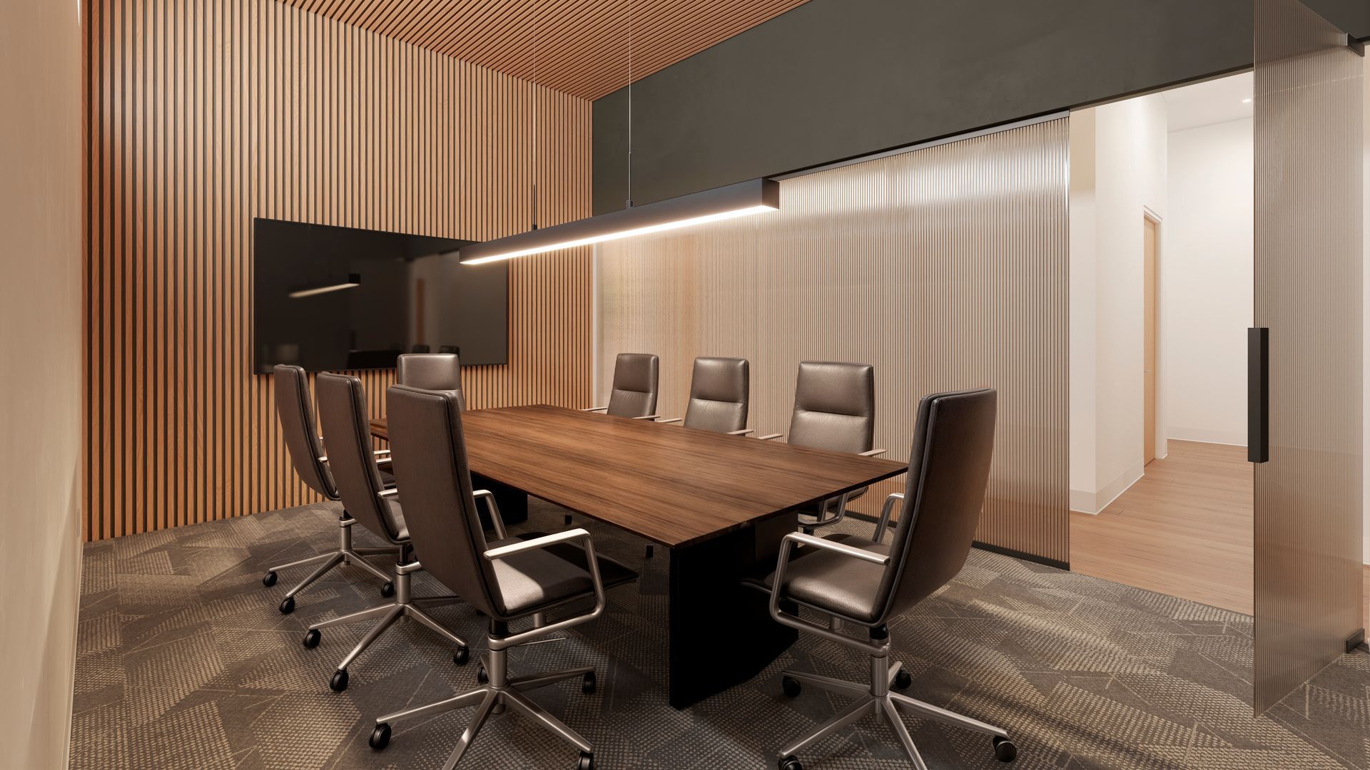 A conference room with a long wooden table and chairs.
