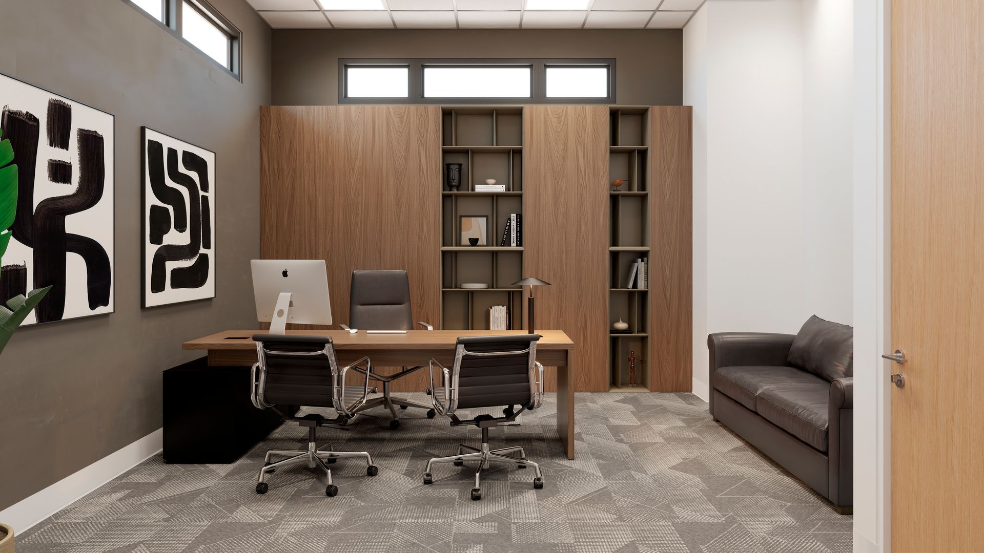 An office with a desk , chairs , a couch and a computer.