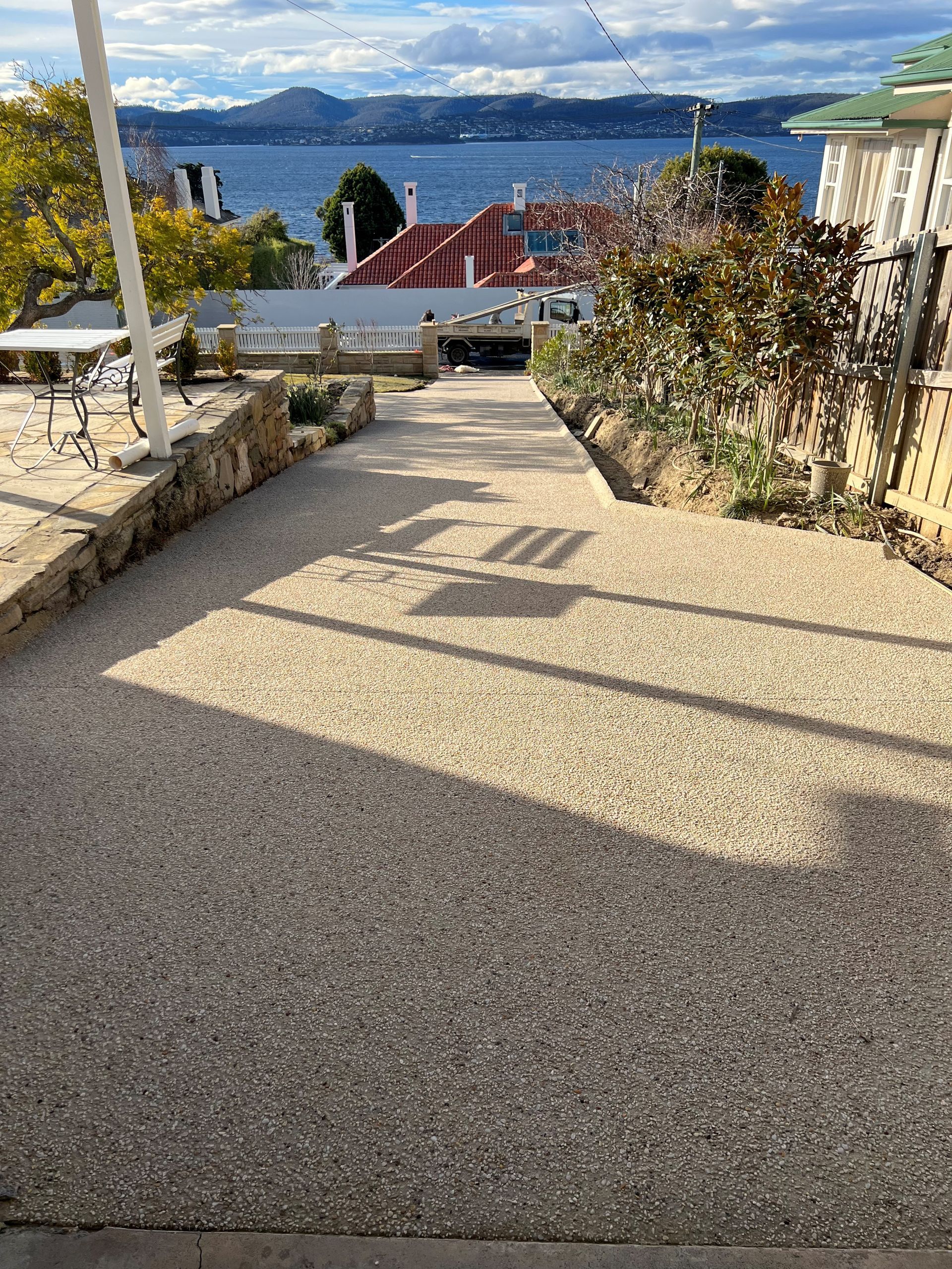 A concrete walkway leading up to a house with a view of the ocean.