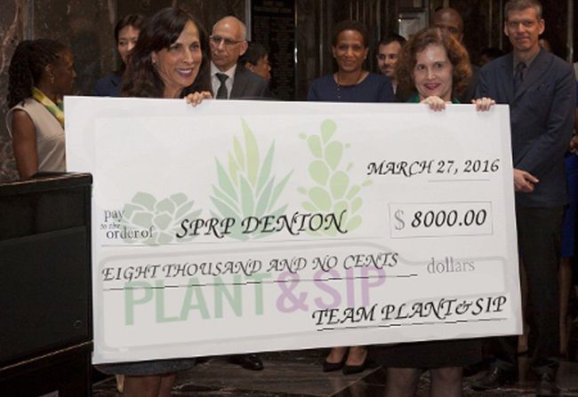 two women are holding a large check that says plant & sip