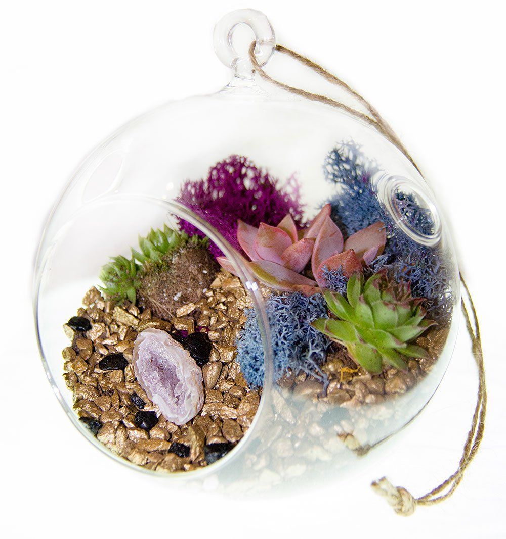 a glass ball filled with flowers and rocks on a string .