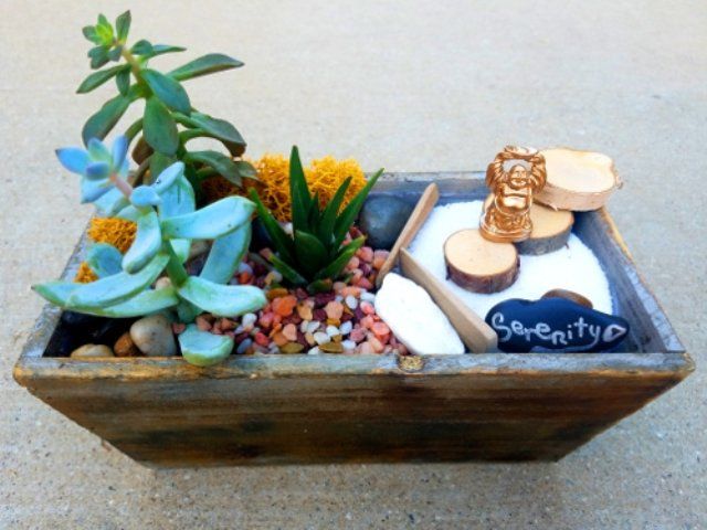 a wooden box filled with plants and a sign that says serenity