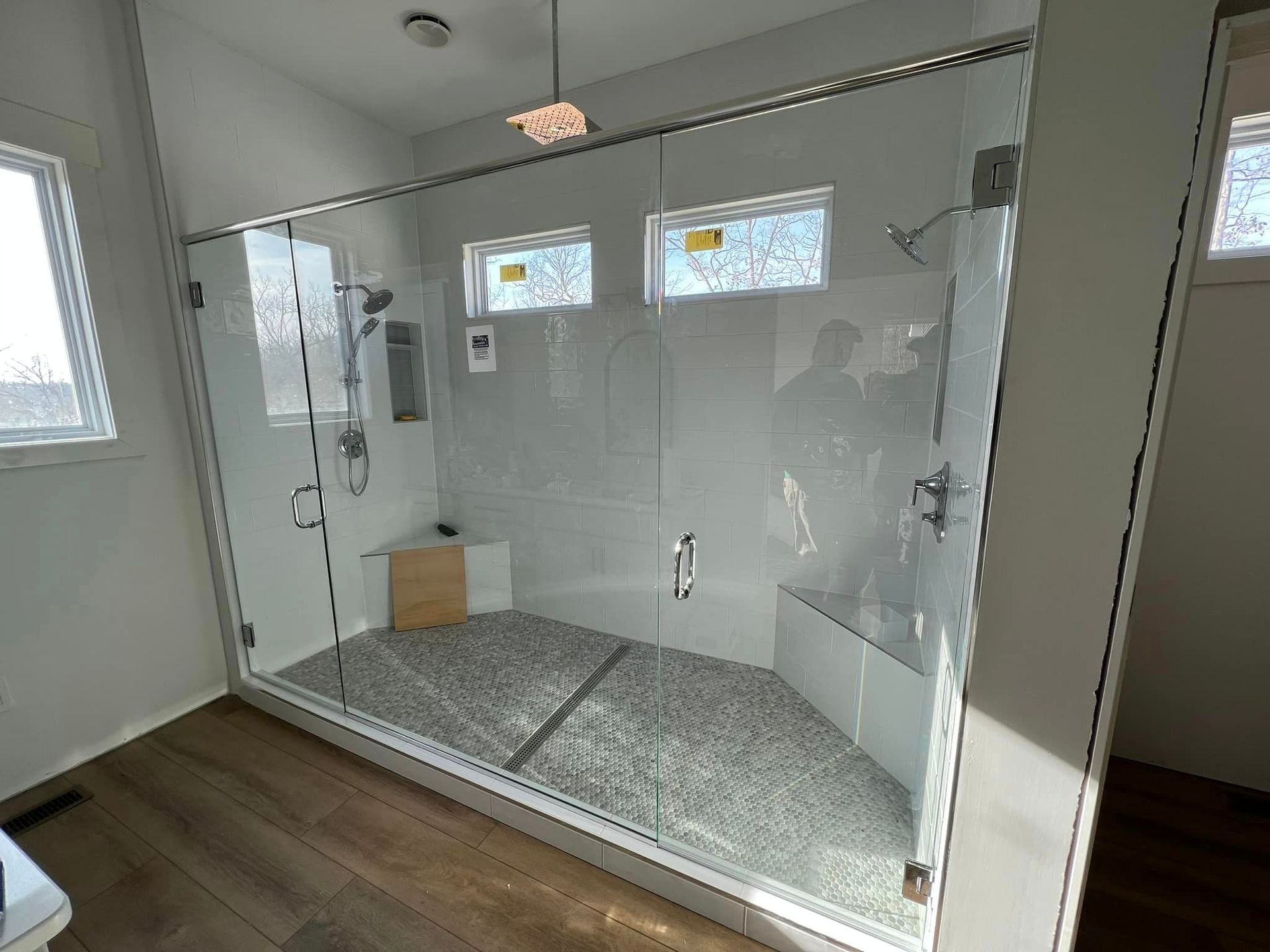 a bathroom with a walk in shower with a glass door .
