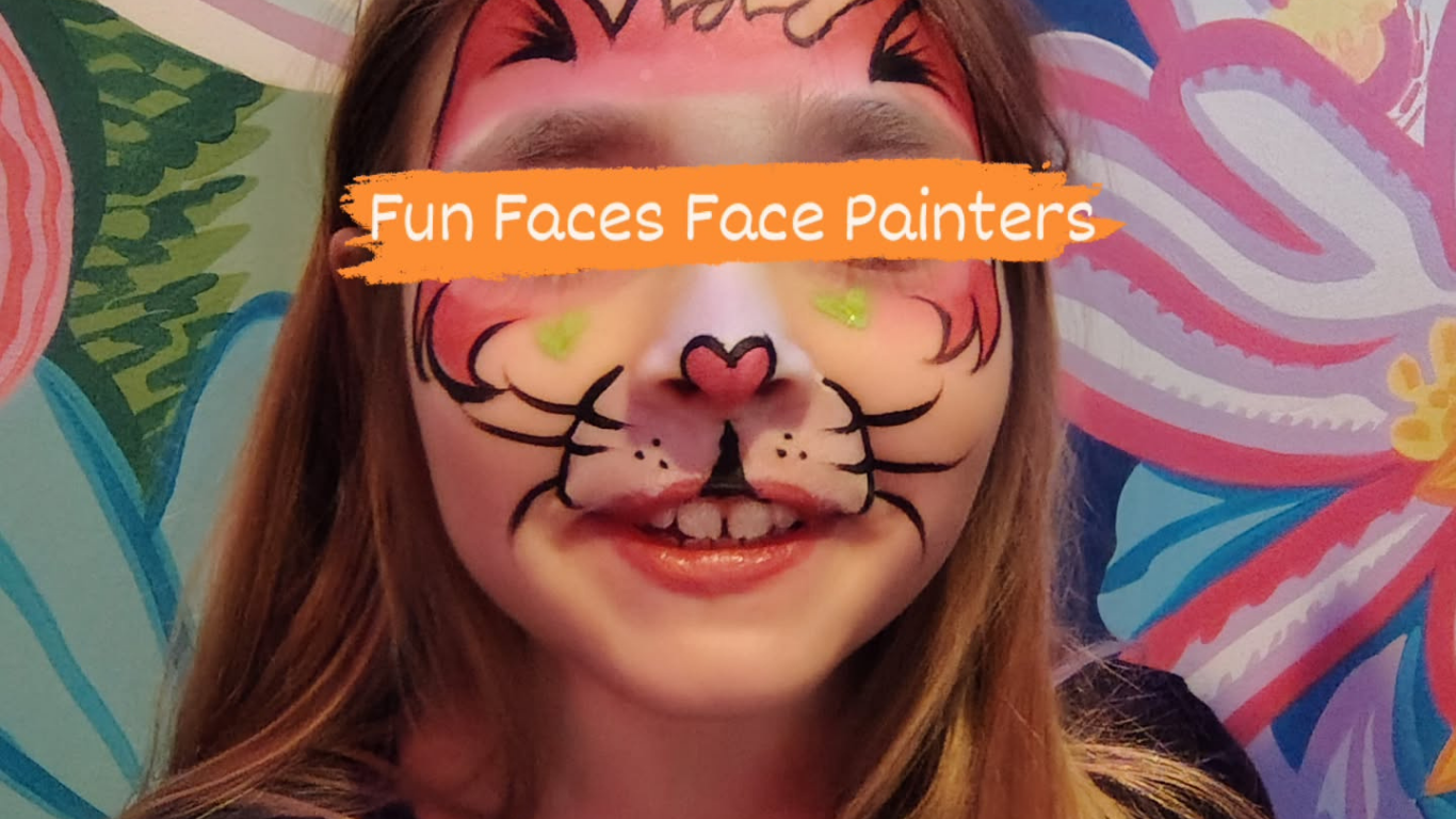 Girl with tiger face paint, smiling, in front of a colorful floral background.