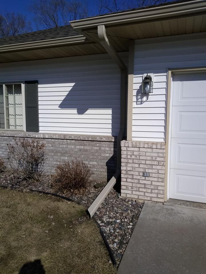 House With White Siding And Bricks – Bangor, WI – Rain Away