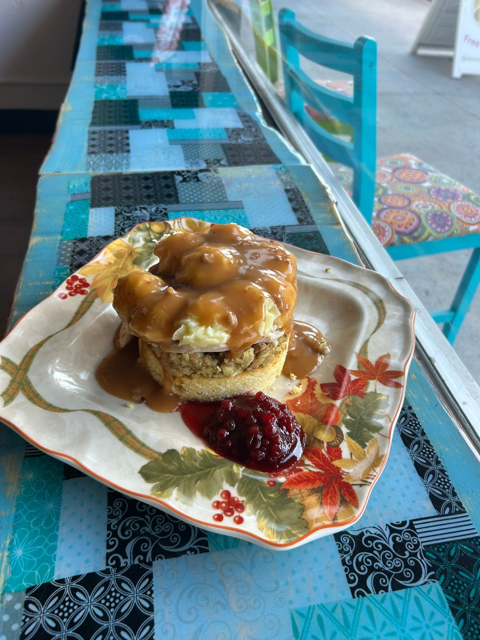 A plate of food with gravy and cranberry sauce on a table.