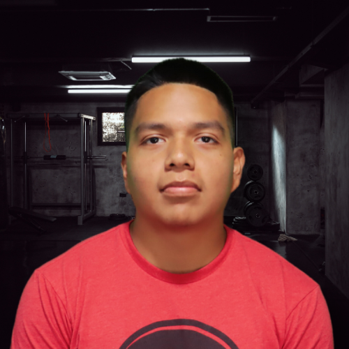 Man wearing a red shirt in front of a dimly lit room with workout equipment.