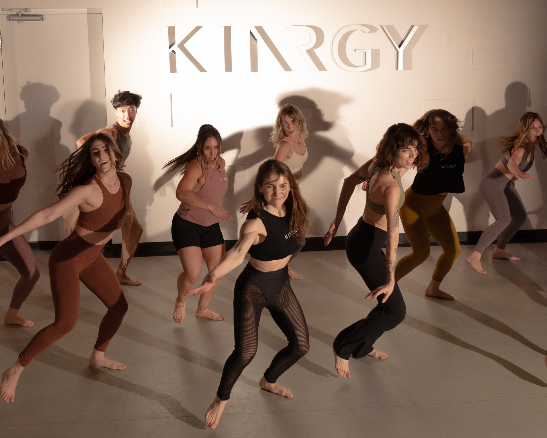 A group of people are dancing in a fitness space.