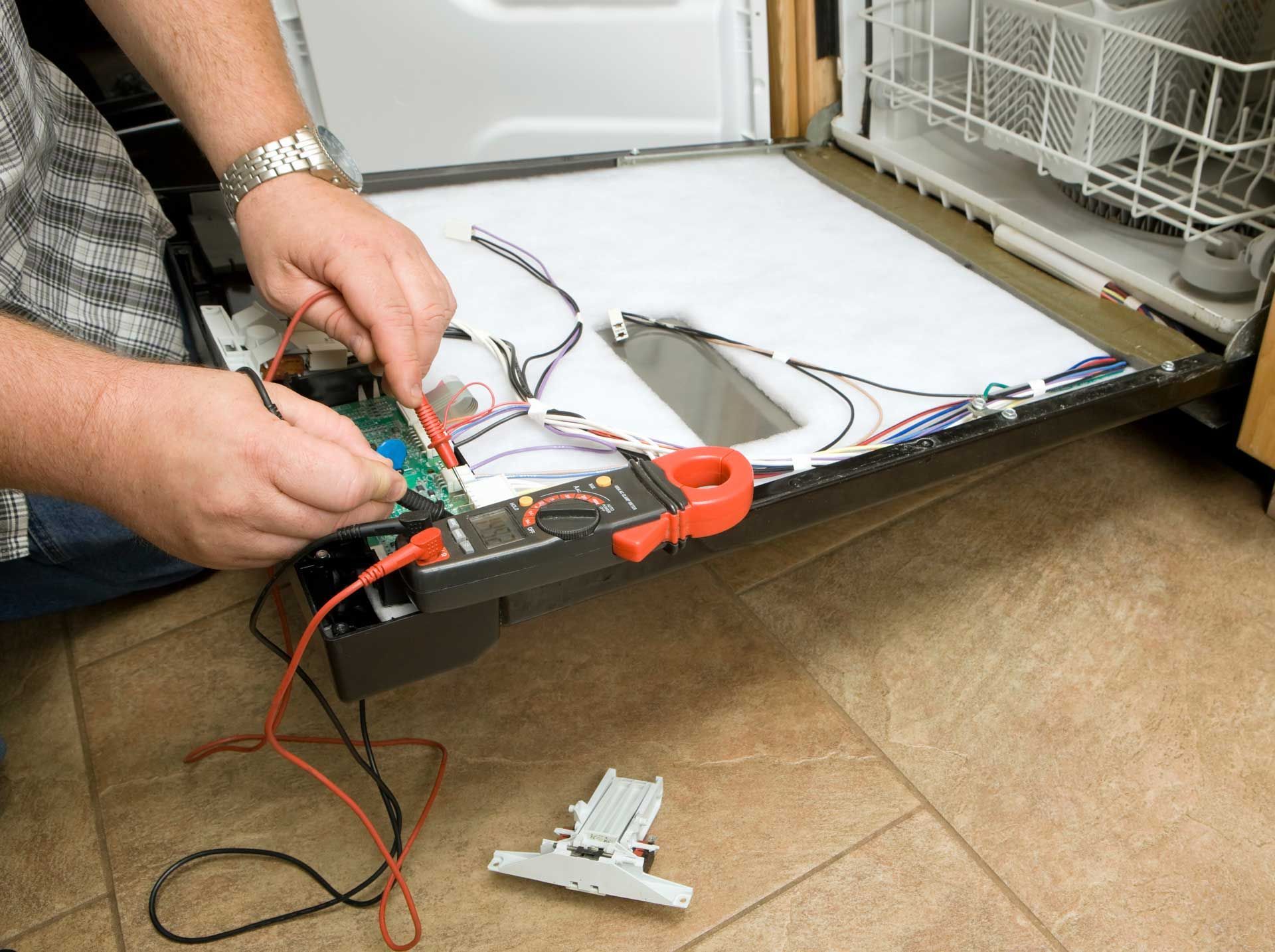 Person using a multimeter to test the electrical components of a dishwasher.