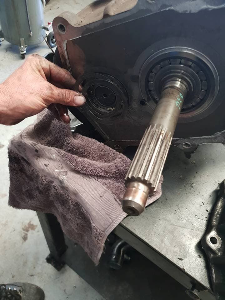 A Man Repairs a Gear Box in a Garage