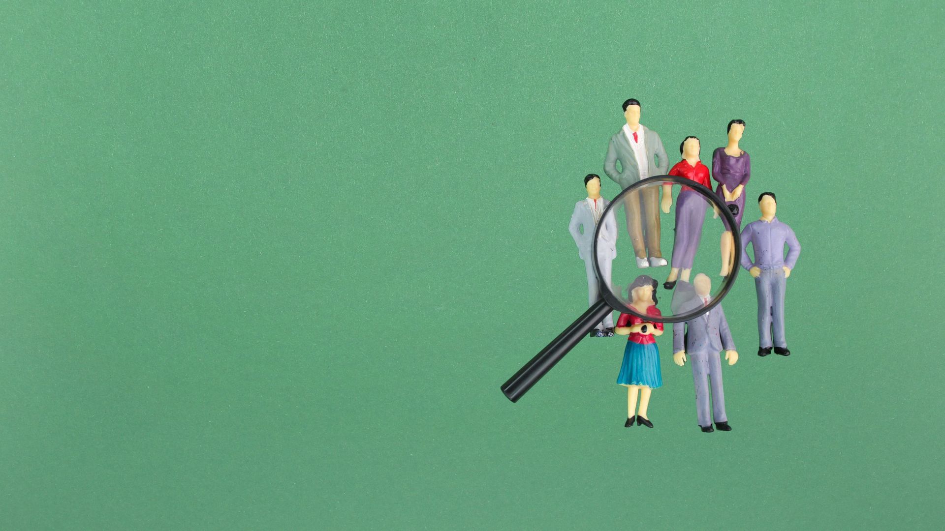 A group of people are standing around a magnifying glass.