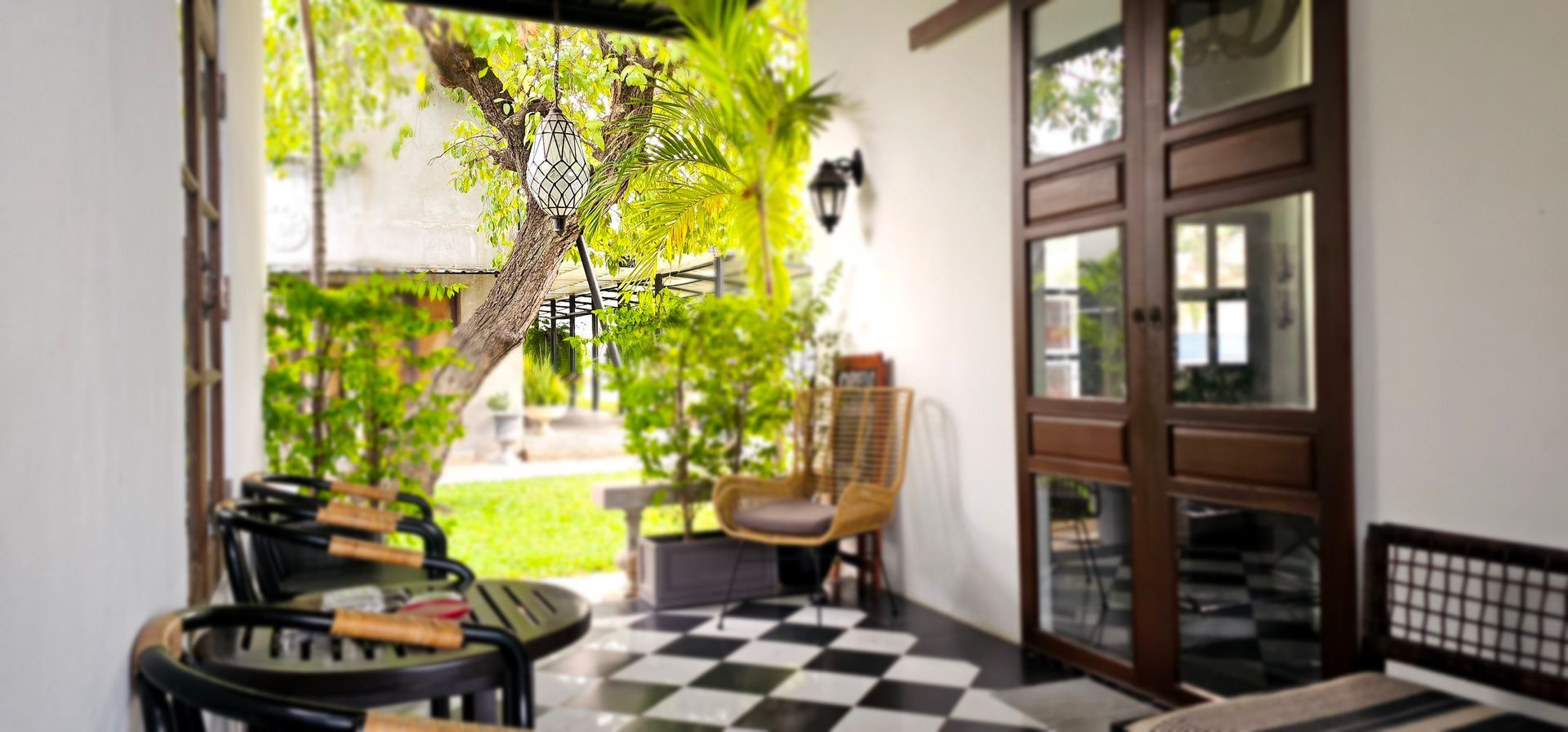 A porch with a table and chairs and a checkered floor.